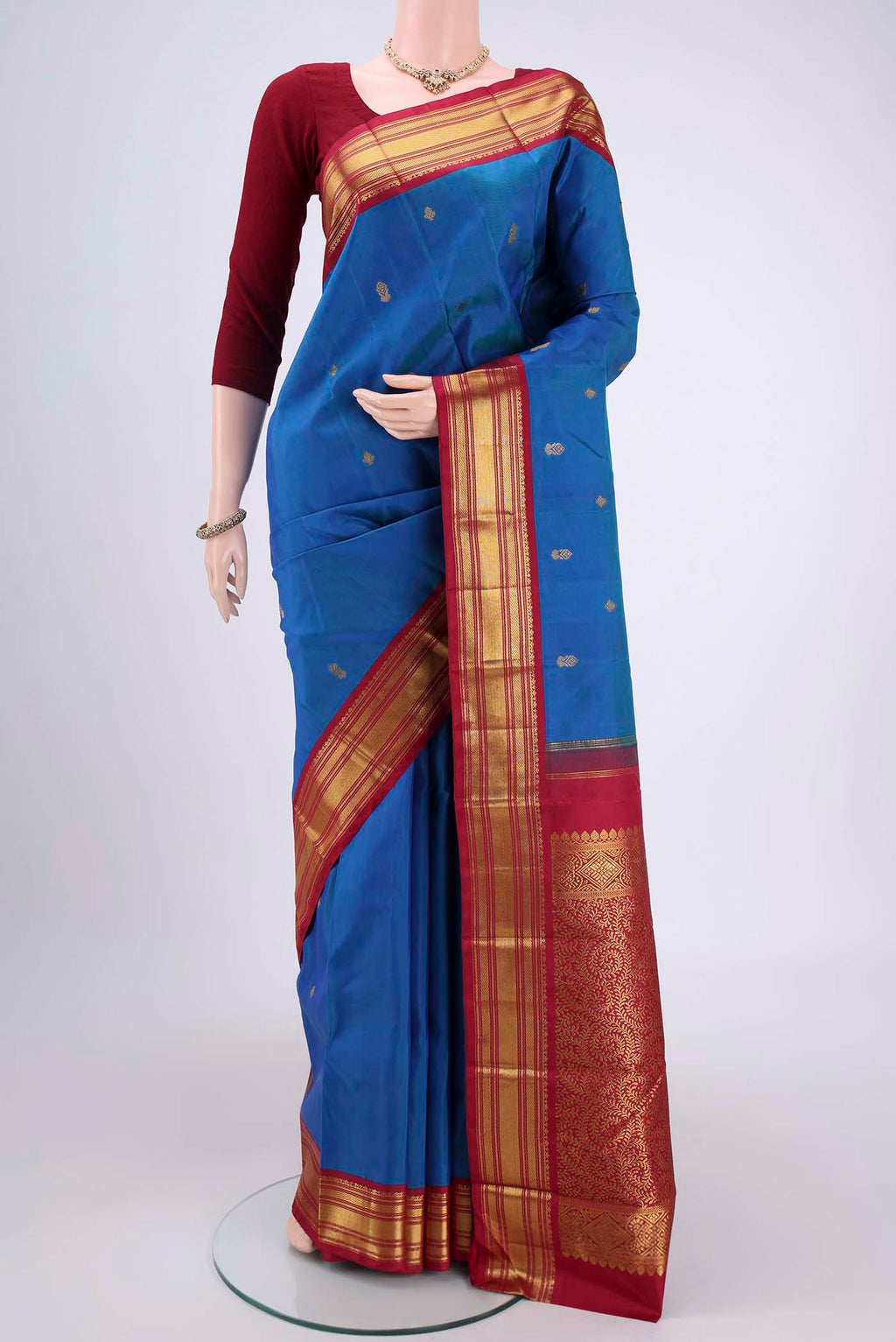 Blue Kanchipuram Silk Saree with Zari Butta on the body and Zari Border.  displayed on a mannequin