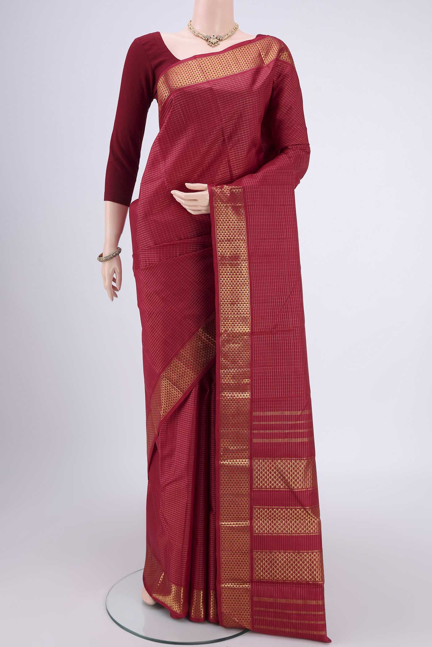 Maroon Kanchipuram Silk Saree with Checked design on the body and Zari Border.  displayed on a mannequin
