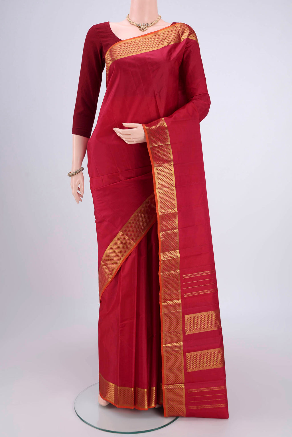 Maroon Kanchipuram Silk Saree with Plain Body and Zari Border.  displayed on a mannequin