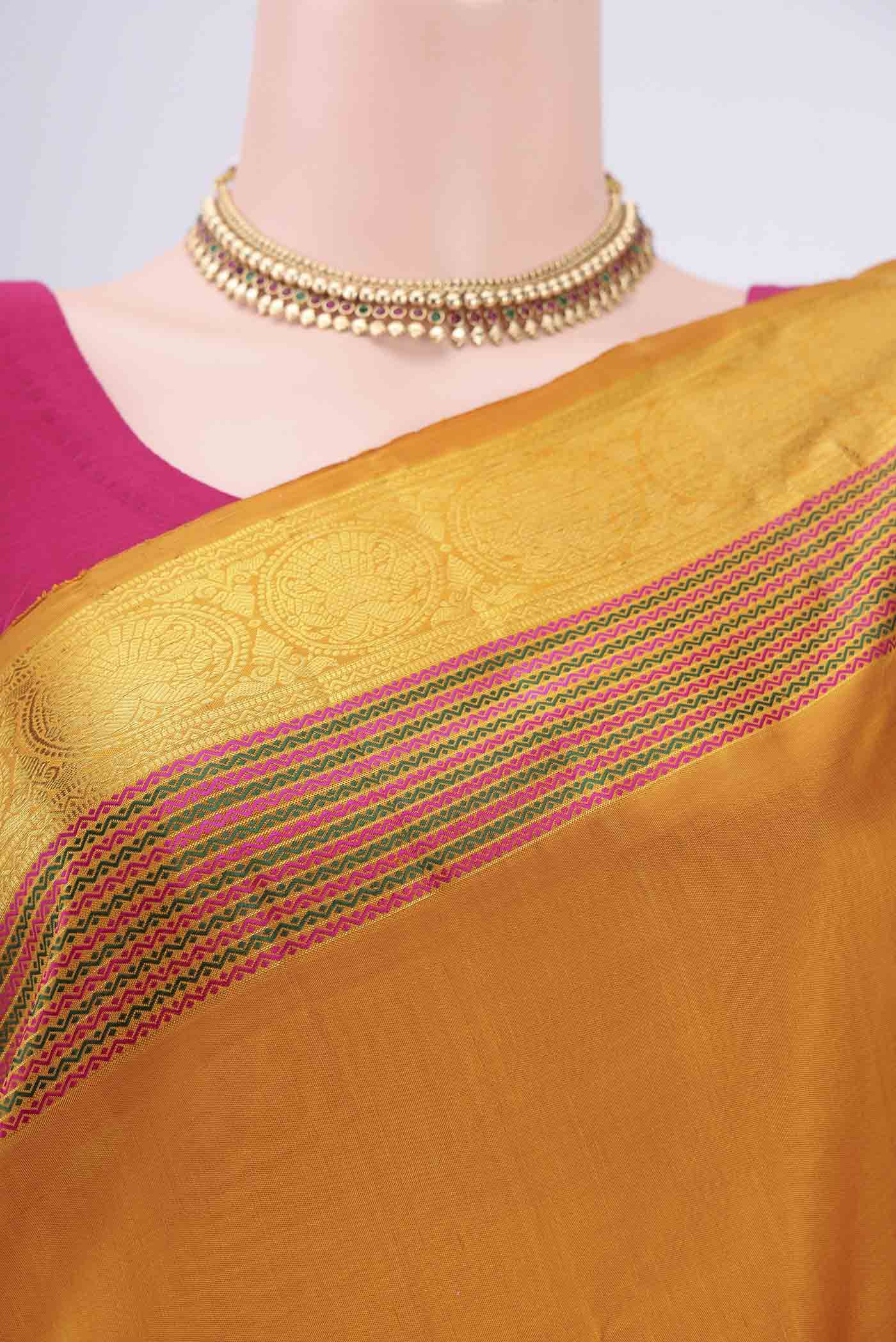 Border image of Mustard Kanchipuram Silk Saree with Plain Body and Zari And Thread Border. 
