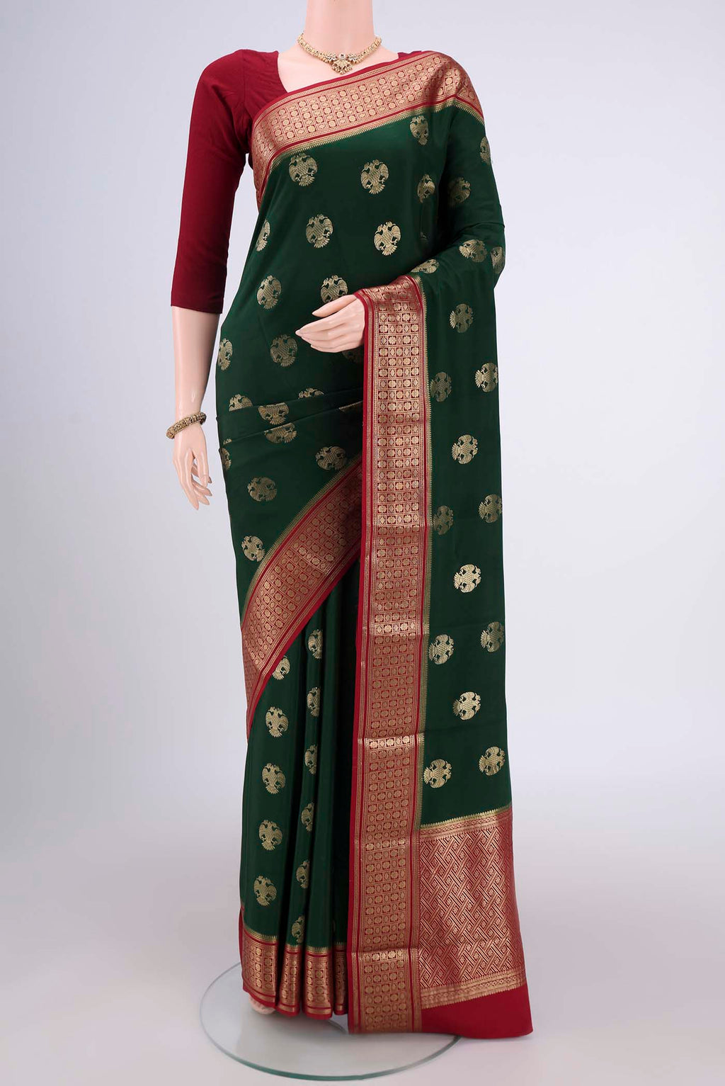 Bottle Green Mysore Crepe Saree with Jacquard design on the body and Zari Border.  displayed on a mannequin