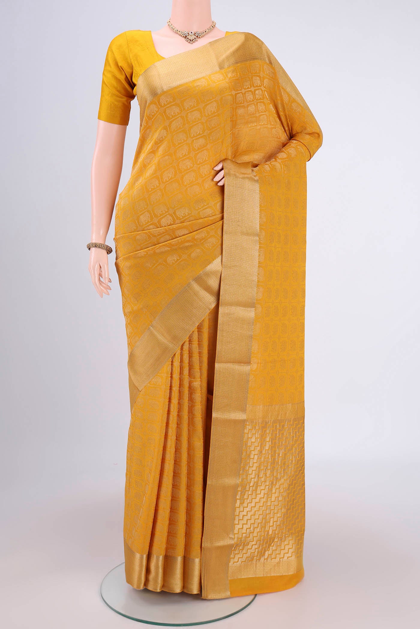 Mustard Mysore Crepe Saree with Zari Brocade on the body and Zari Border.  displayed on a mannequin