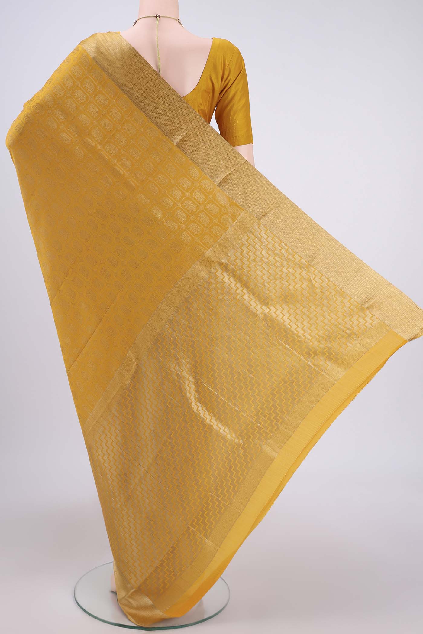 Flat view of Mustard Mysore Crepe Saree with Zari Brocade on the body and Zari Border. 