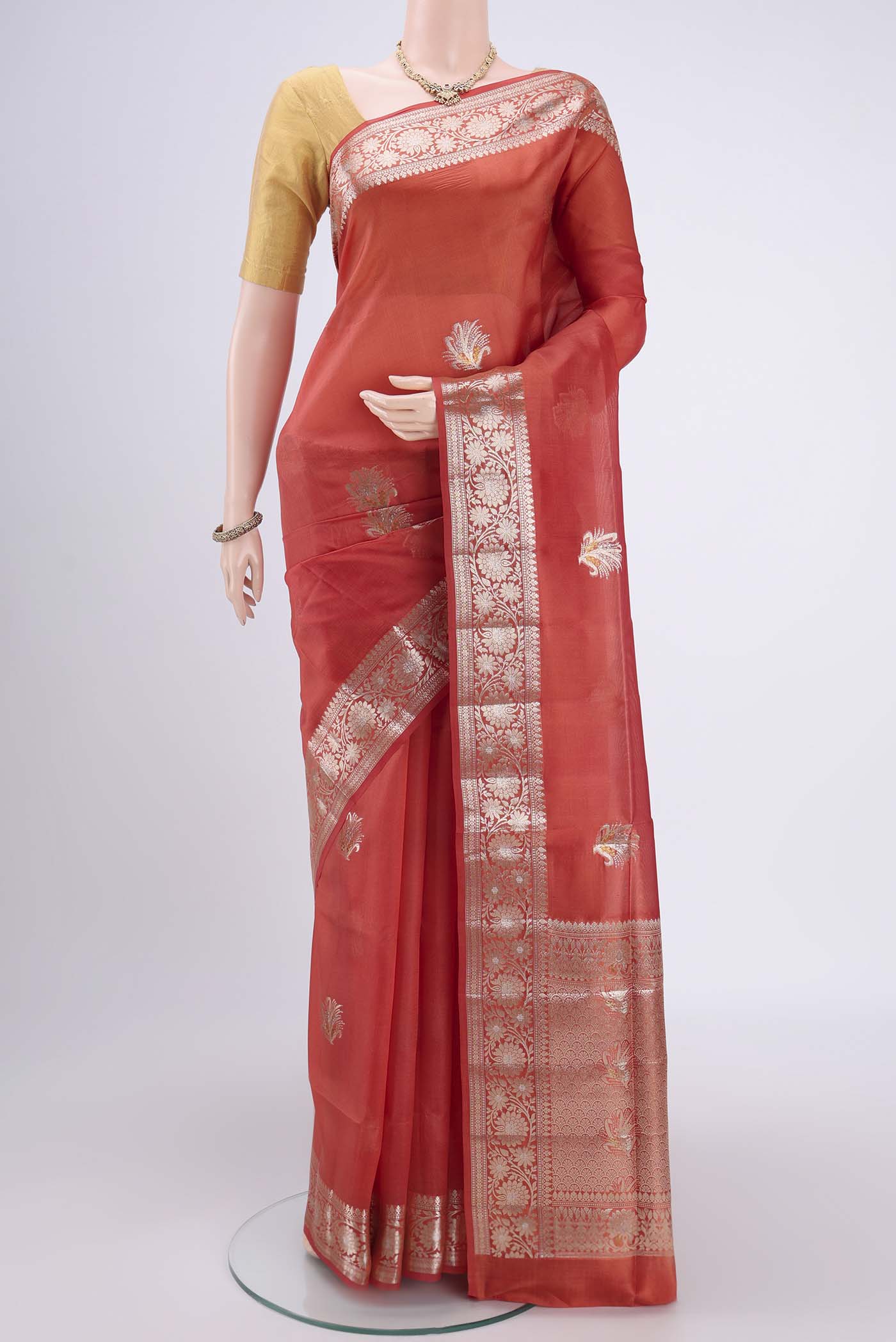 Brick Orange Banarasi Raw Silk Saree with Zari Butta on the body and Zari Border.  displayed on a mannequin