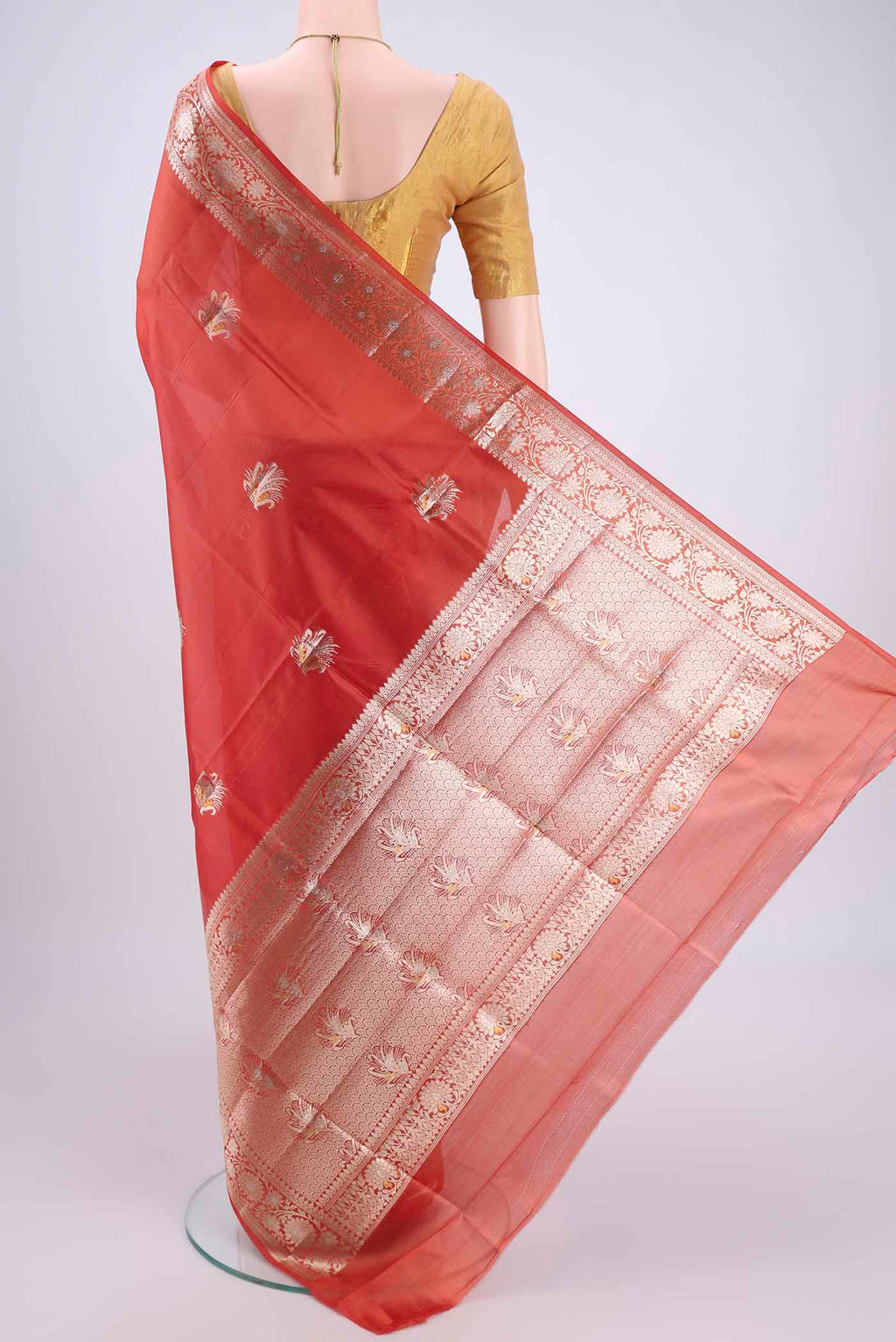 Flat view of Brick Orange Banarasi Raw Silk Saree with Zari Butta on the body and Zari Border. 
