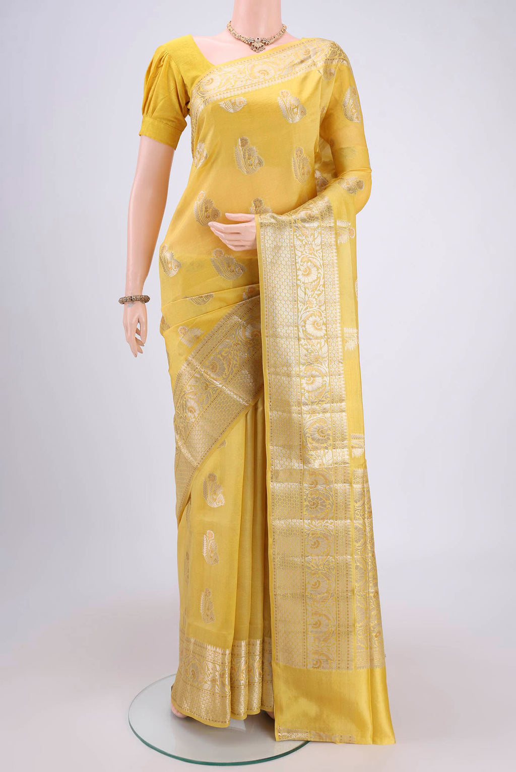 Yellow Banarasi Raw Silk Saree with Zari Butta on the body and Zari Border.  displayed on a mannequin