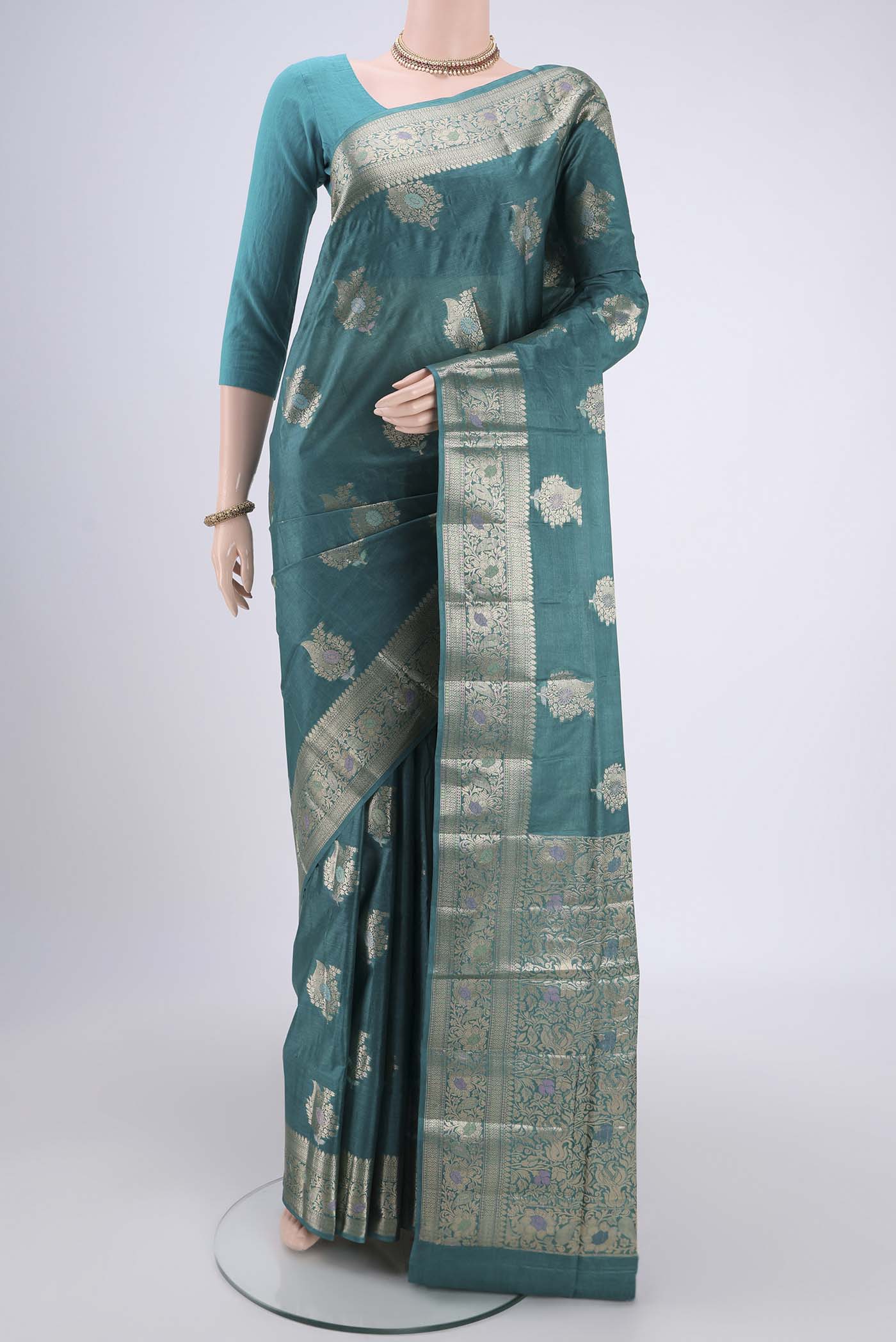 Turquoise Banarasi Tussar Silk Saree with Zari And Thread Butta on the body and Zari And Thread Border.  displayed on a mannequin