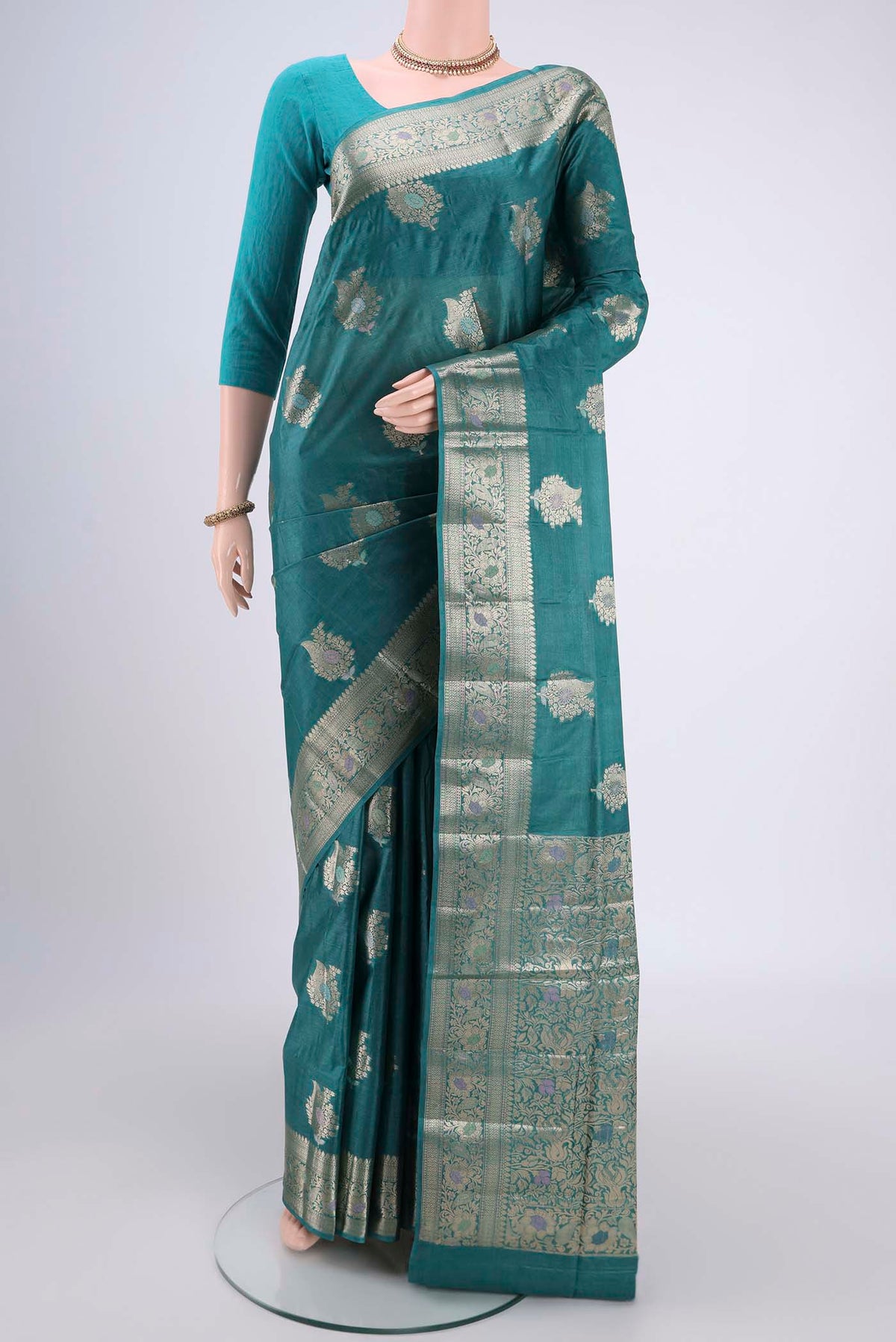 Turquoise Banarasi Tussar Silk Saree with Zari And Thread Butta on the body and Zari And Thread Border.  displayed on a mannequin