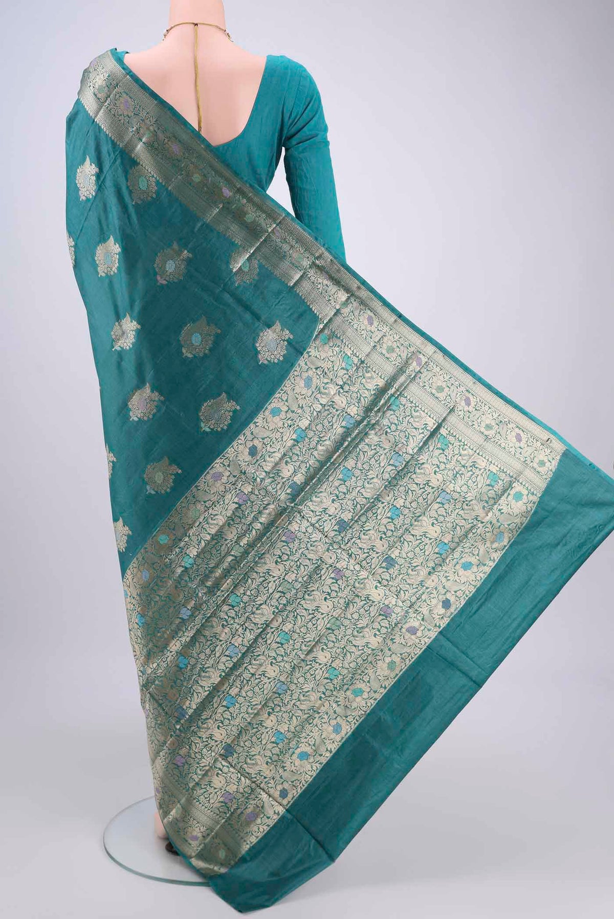 Flat view of Turquoise Banarasi Tussar Silk Saree with Zari And Thread Butta on the body and Zari And Thread Border. 