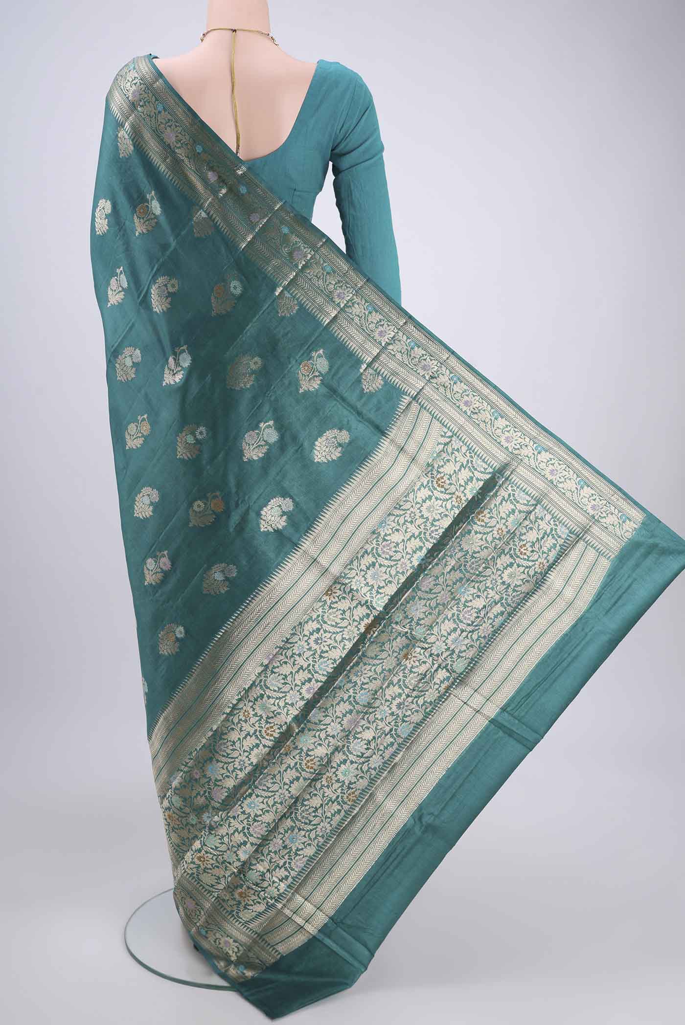 Flat view of Turquoise Banarasi Tussar Silk Saree with Zari And Thread Butta on the body and Zari And Thread Border. 