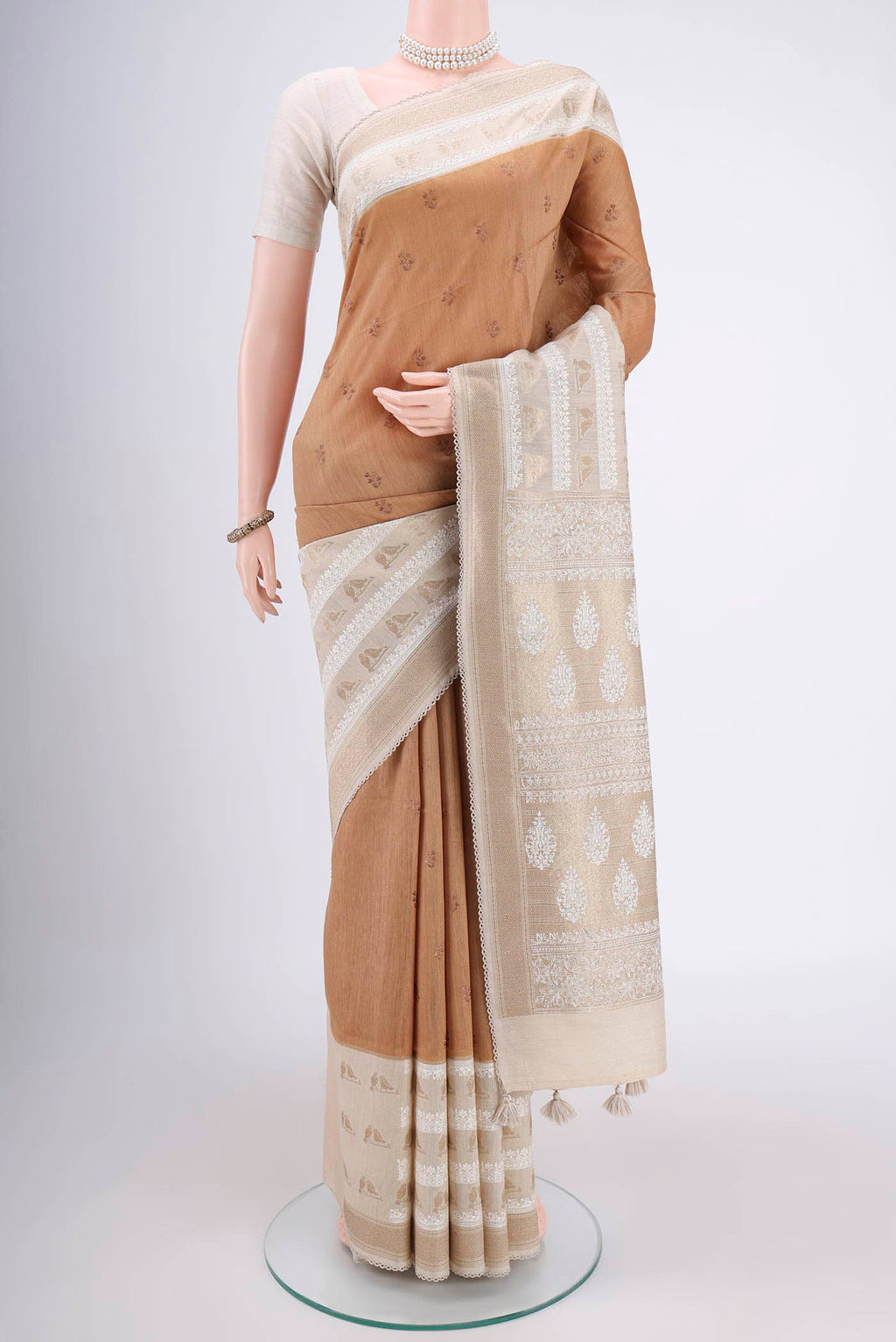 Dark Beige Tussar Silk Saree with Thread Butta on the body and Zari Border.  displayed on a mannequin