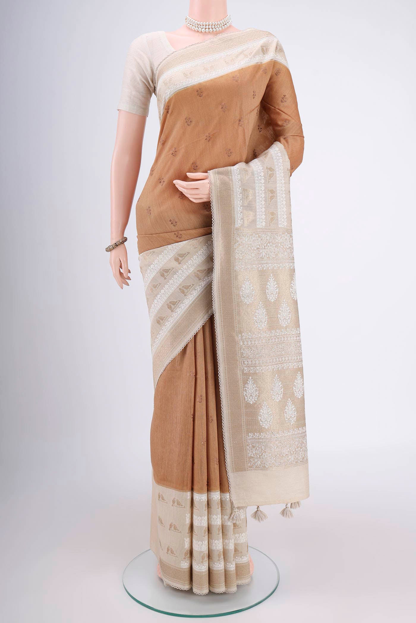 Dark Beige Tussar Silk Saree with Thread Butta on the body and Zari Border.  displayed on a mannequin