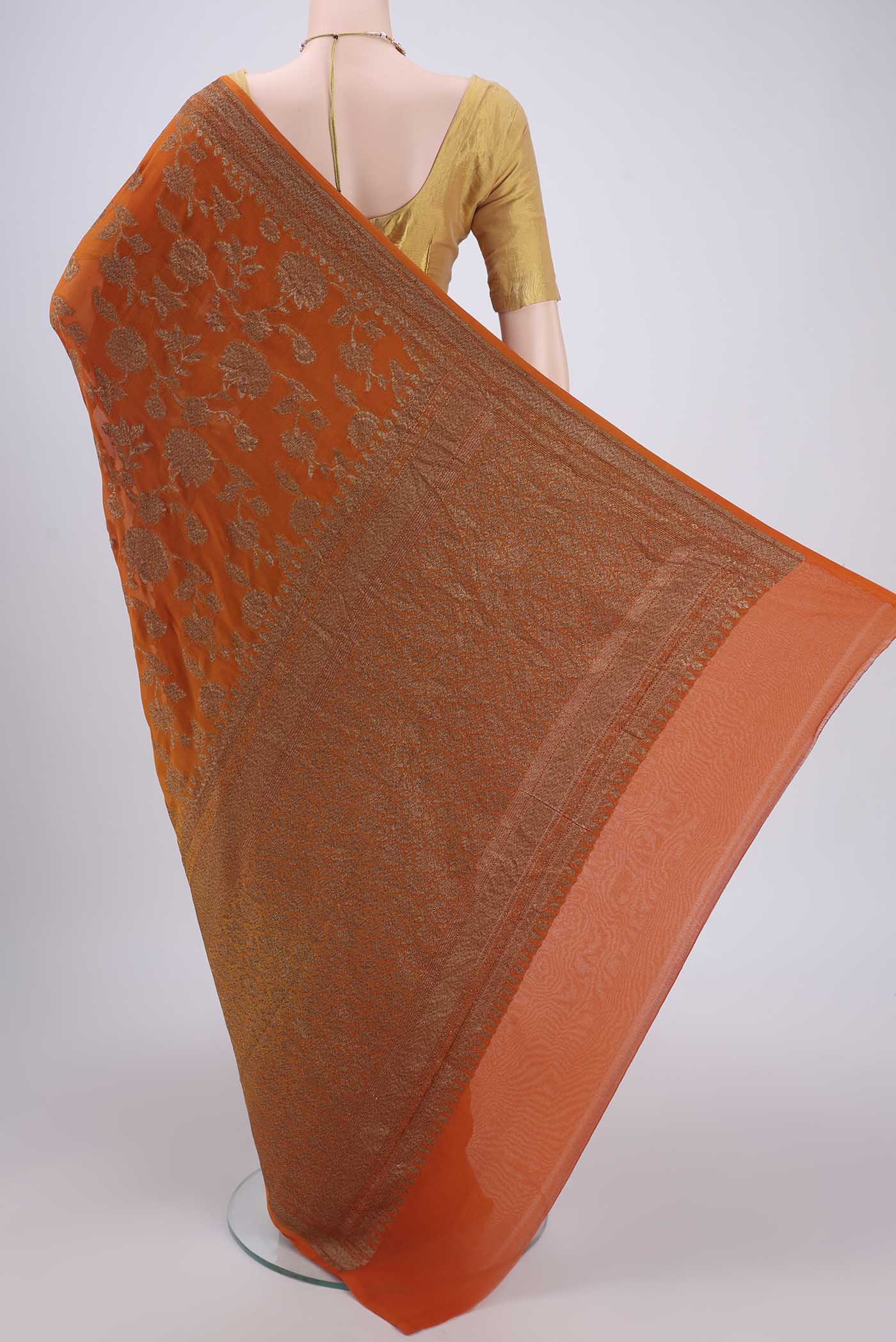 Flat view of Rust Banarasi Georgette Saree with Zari Brocade on the body and Zari Border. 
