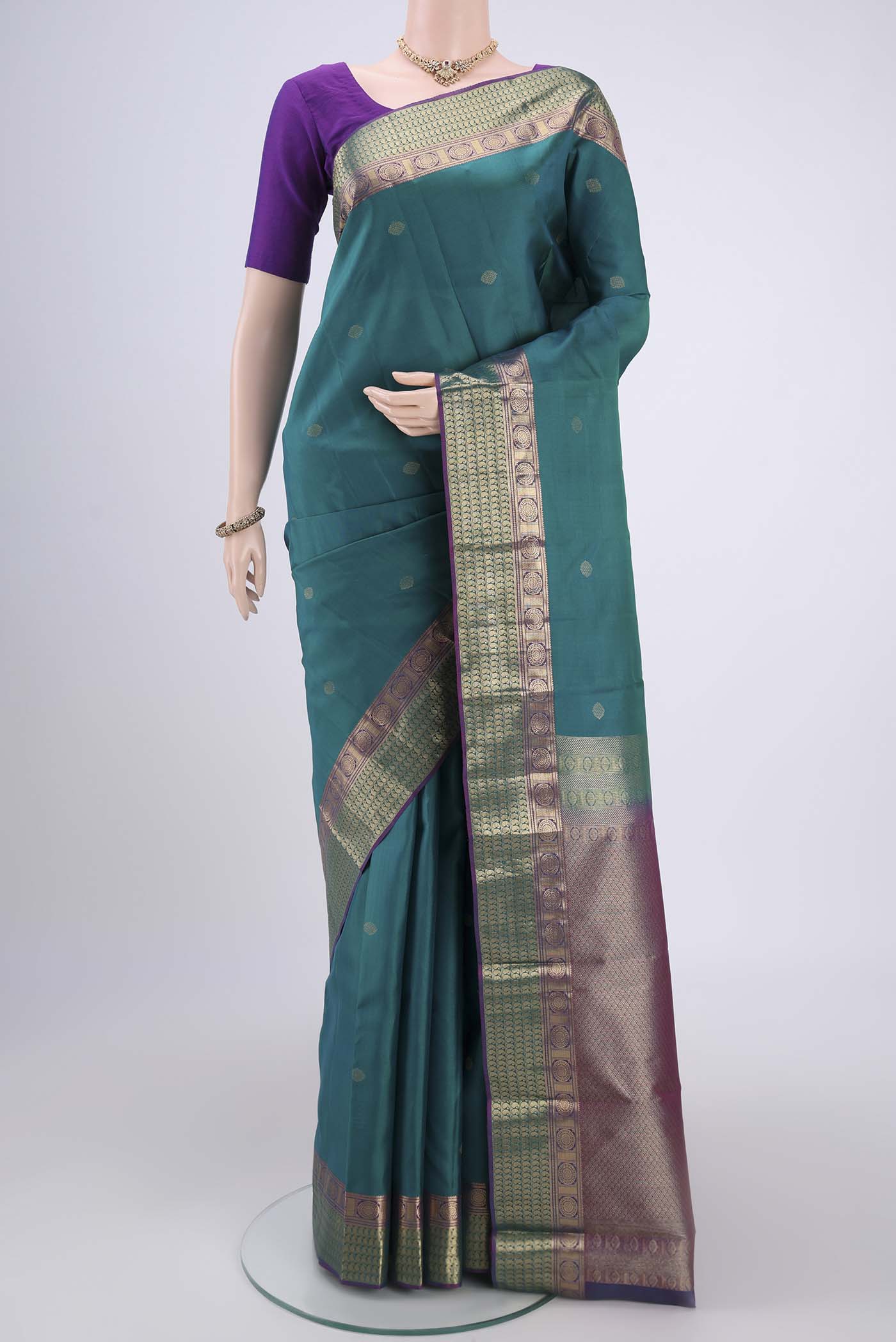 Turquoise Kanchipuram Silk Saree with Zari Butta on the body and Zari Border.  displayed on a mannequin