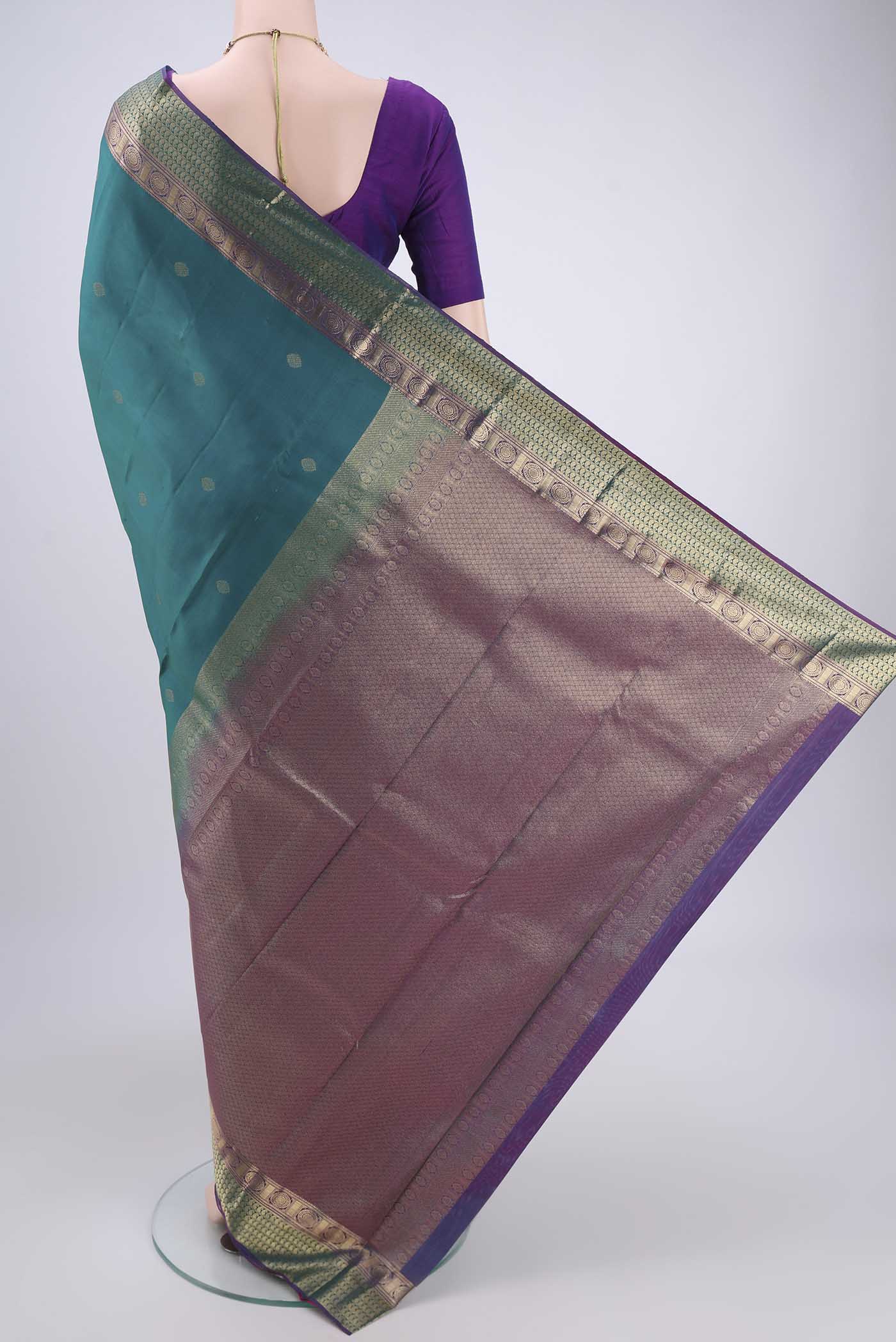 Flat view of Turquoise Kanchipuram Silk Saree with Zari Butta on the body and Zari Border. 