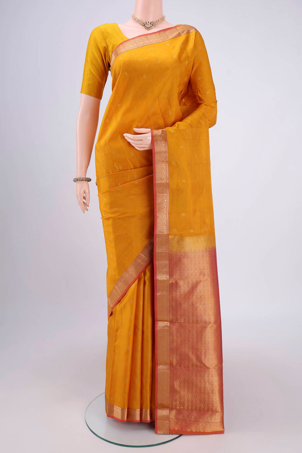 Yellow Kanchipuram Silk Saree with Zari Butta on the body and Zari Border.  displayed on a mannequin