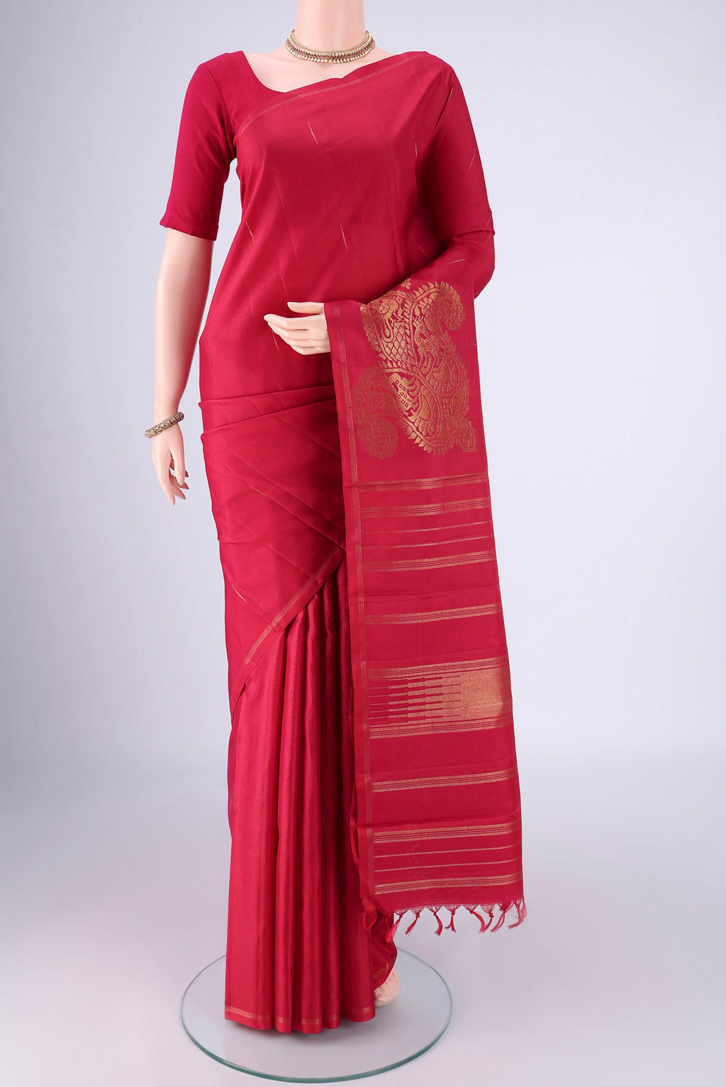 Pure Silk Pure Zari Maroon Kanjivaram Saree with Zari Butta on the body and Without Border.  displayed on a mannequin