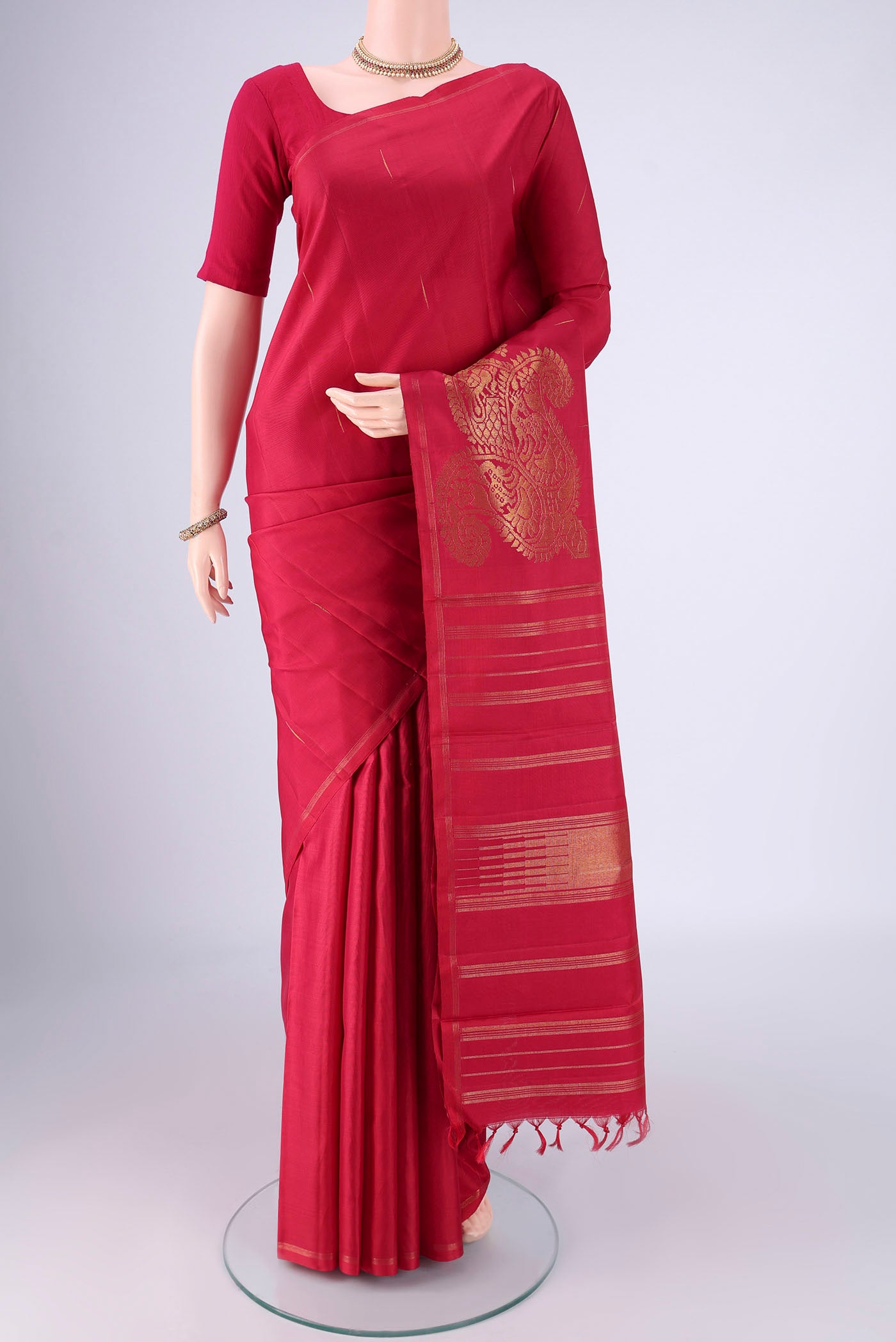 Pure Silk Pure Zari Maroon Kanjivaram Saree with Zari Butta on the body and Without Border.  displayed on a mannequin