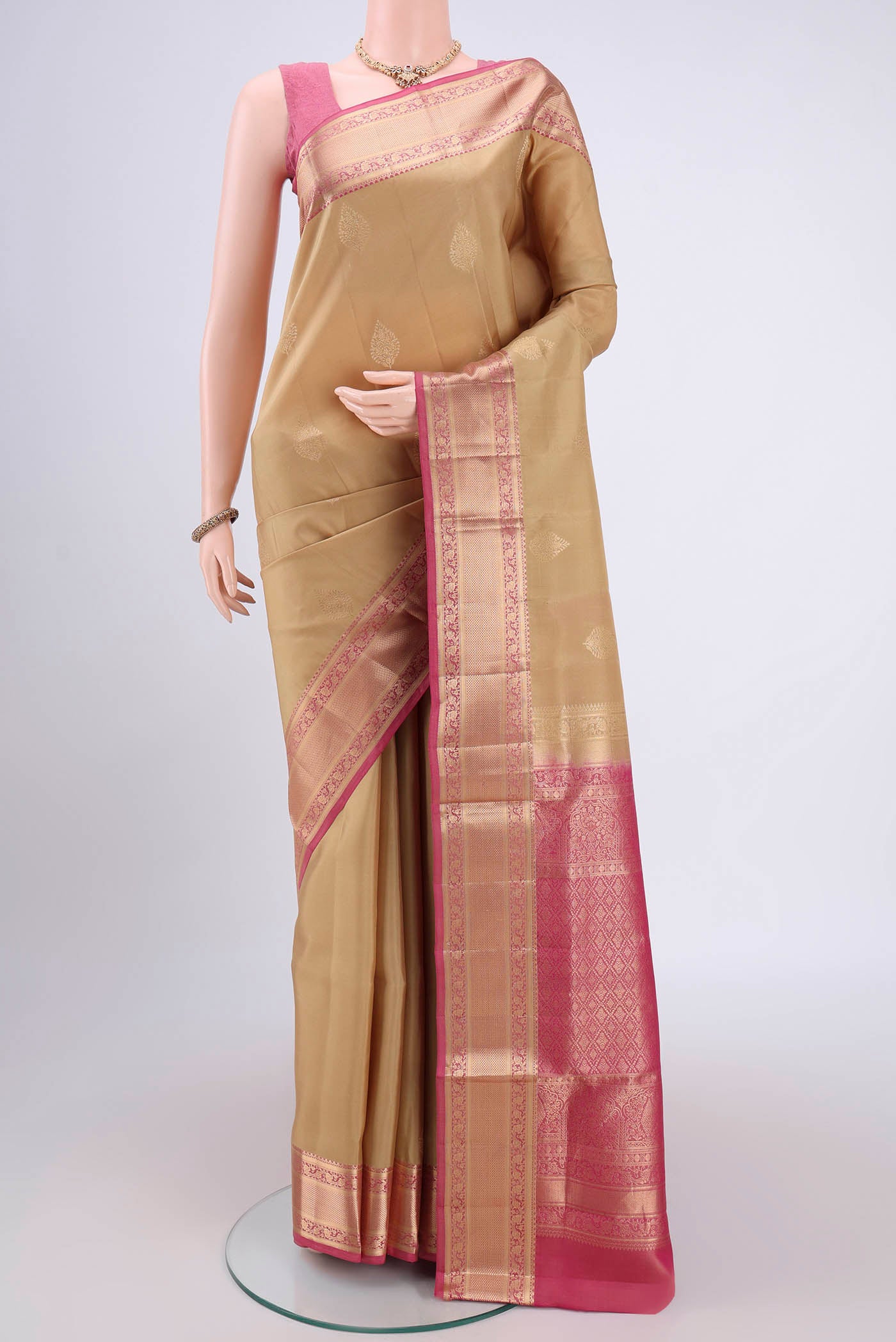 Beige Soft Silk Saree with Zari Butta on the body and Zari Border.  displayed on a mannequin