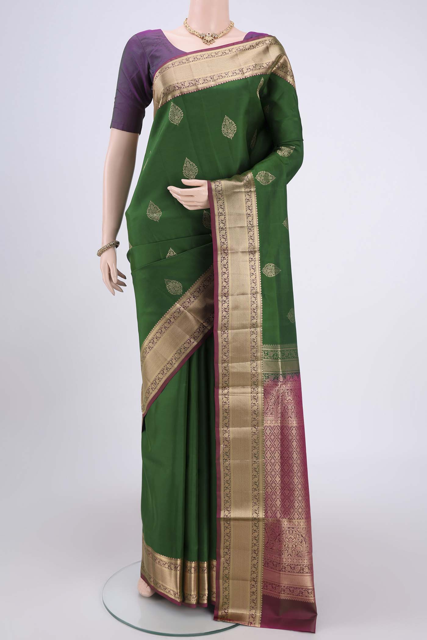 Green Soft Silk Saree with Zari Butta on the body and Zari Border.  displayed on a mannequin