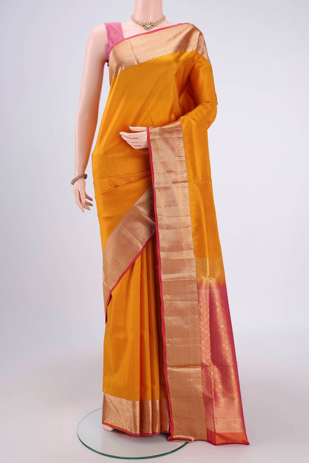 Mustard Soft Silk Saree with Plain Body and Zari Border.  displayed on a mannequin