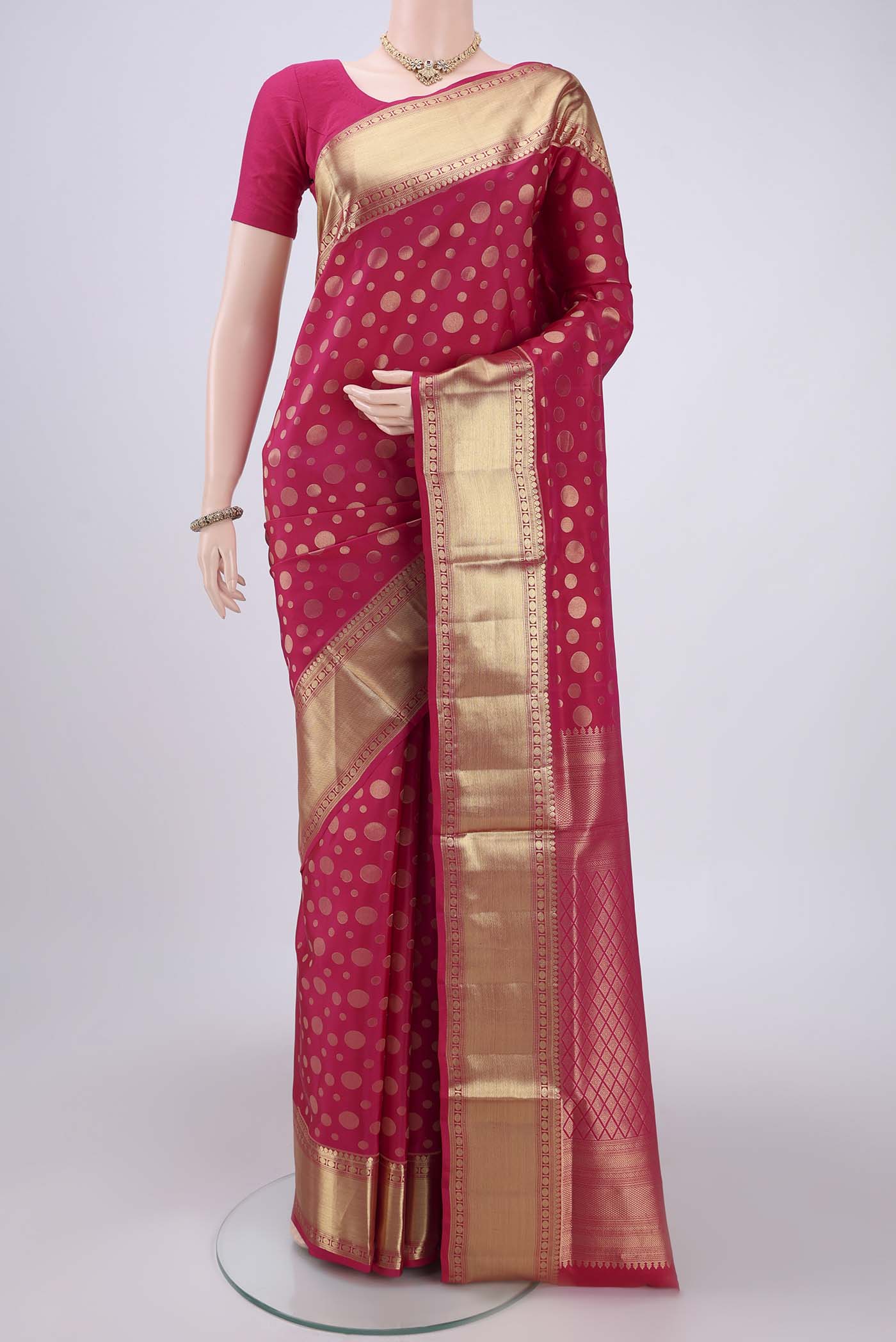 Rani Pink Soft Silk Saree with Polka Dots on the body and Zari Border.  displayed on a mannequin