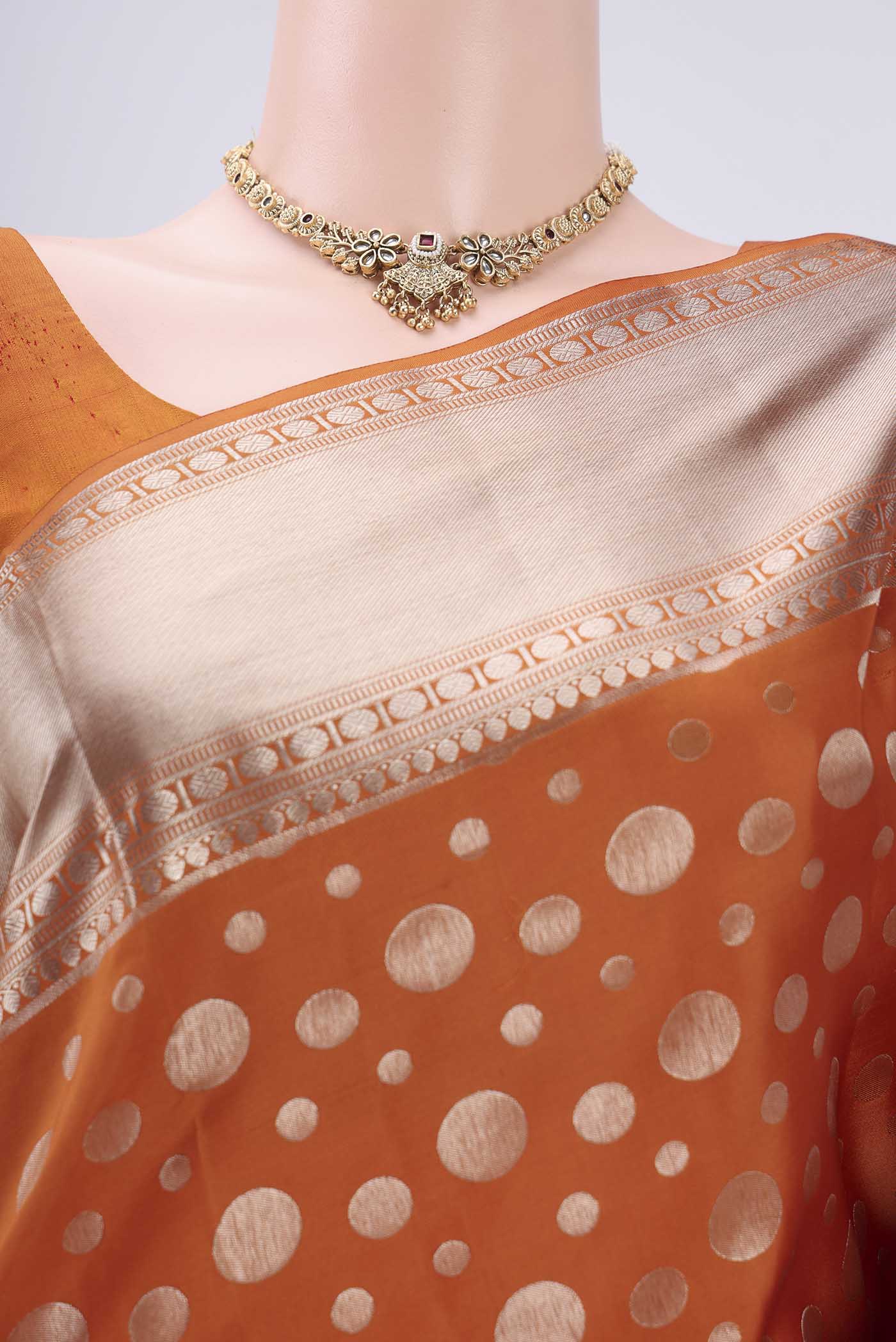 Border image of Rust Soft Silk Saree with Polka Dots on the body and Zari Border. 
