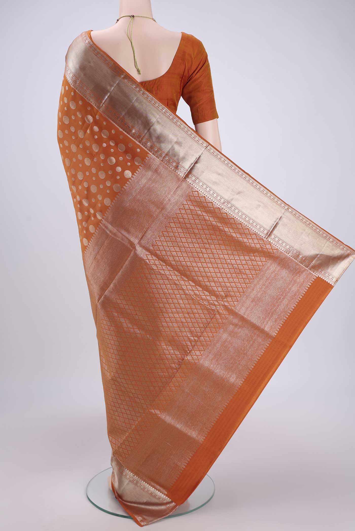 Flat view of Rust Soft Silk Saree with Polka Dots on the body and Zari Border. 