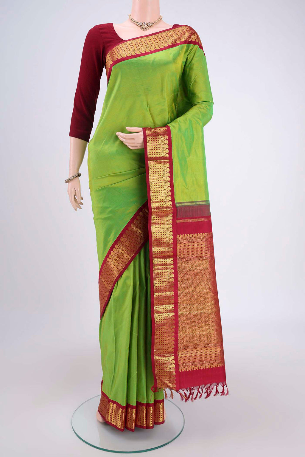 Parrot Green Kanjivaram Silk Saree with Plain Body and Zari Border.  displayed on a mannequin