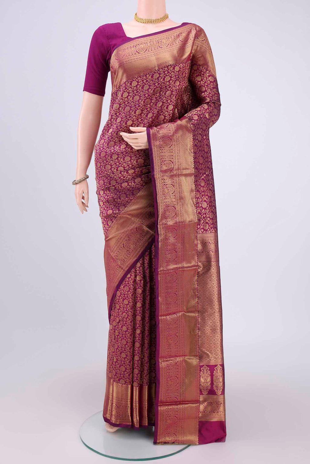 Magenta Kanjivaram Silk Saree with Zari Butta on the body and Zari Border.  displayed on a mannequin