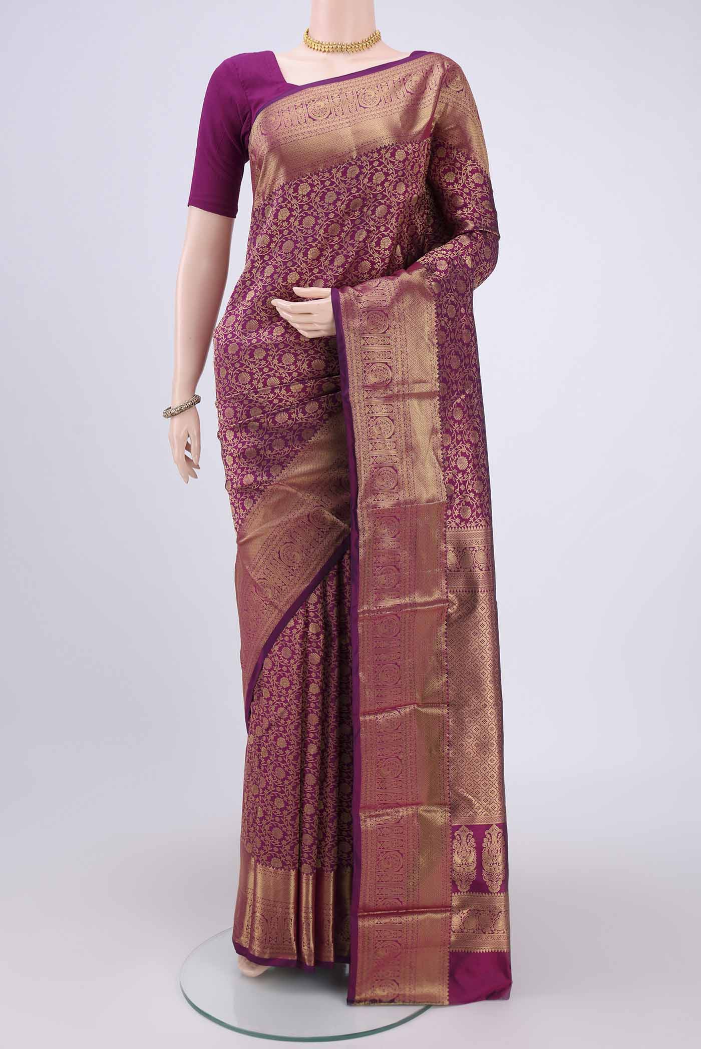 Magenta Kanjivaram Silk Saree with Zari Butta on the body and Zari Border.  displayed on a mannequin
