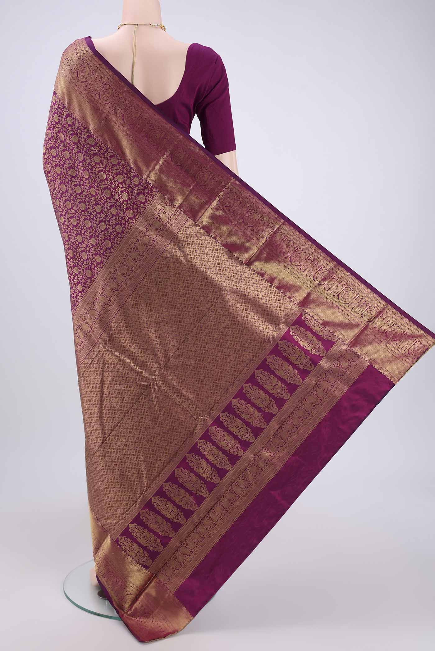 Flat view of Magenta Kanjivaram Silk Saree with Zari Butta on the body and Zari Border. 