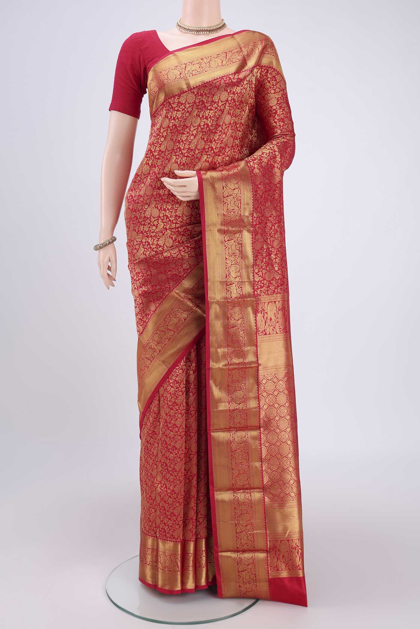Red Kanjivaram Silk Saree with Zari Butta on the body and Zari Border.  displayed on a mannequin