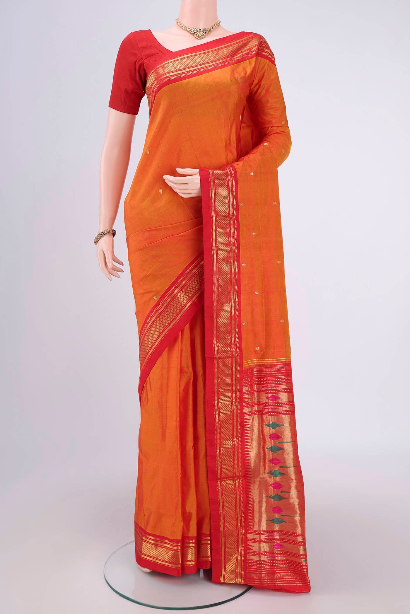 Orange Paithani Silk Saree with Zari Butta on the body and Zari Border.  displayed on a mannequin
