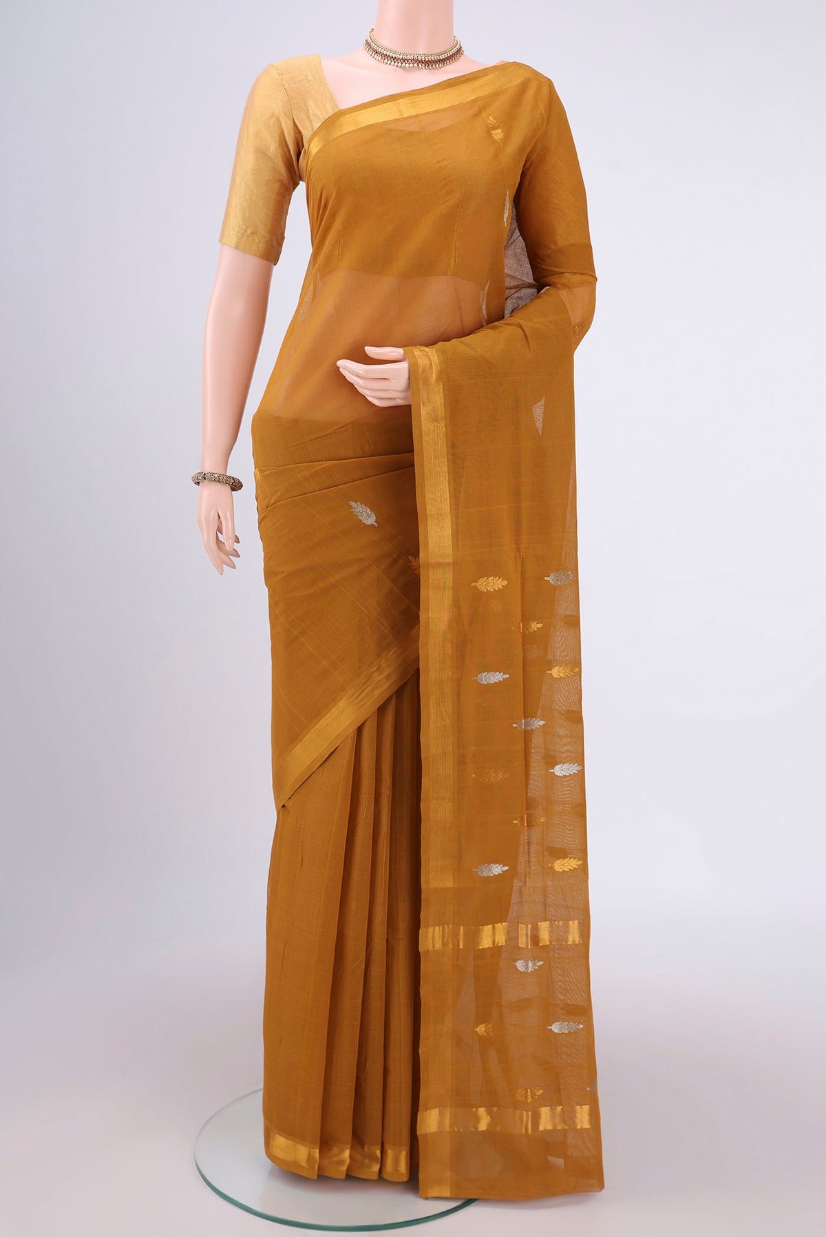 Mustard Cotton Saree with Zari Butta on the body and Zari Border.  displayed on a mannequin