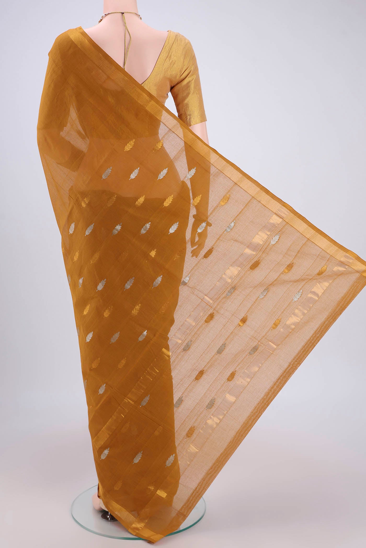 Flat view of Mustard Cotton Saree with Zari Butta on the body and Zari Border. 