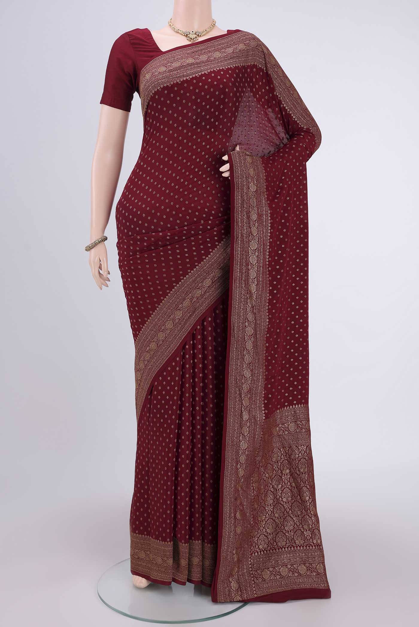 Maroon Banarasi Georgette Saree with Zari Butta on the body and Zari Border.  displayed on a mannequin