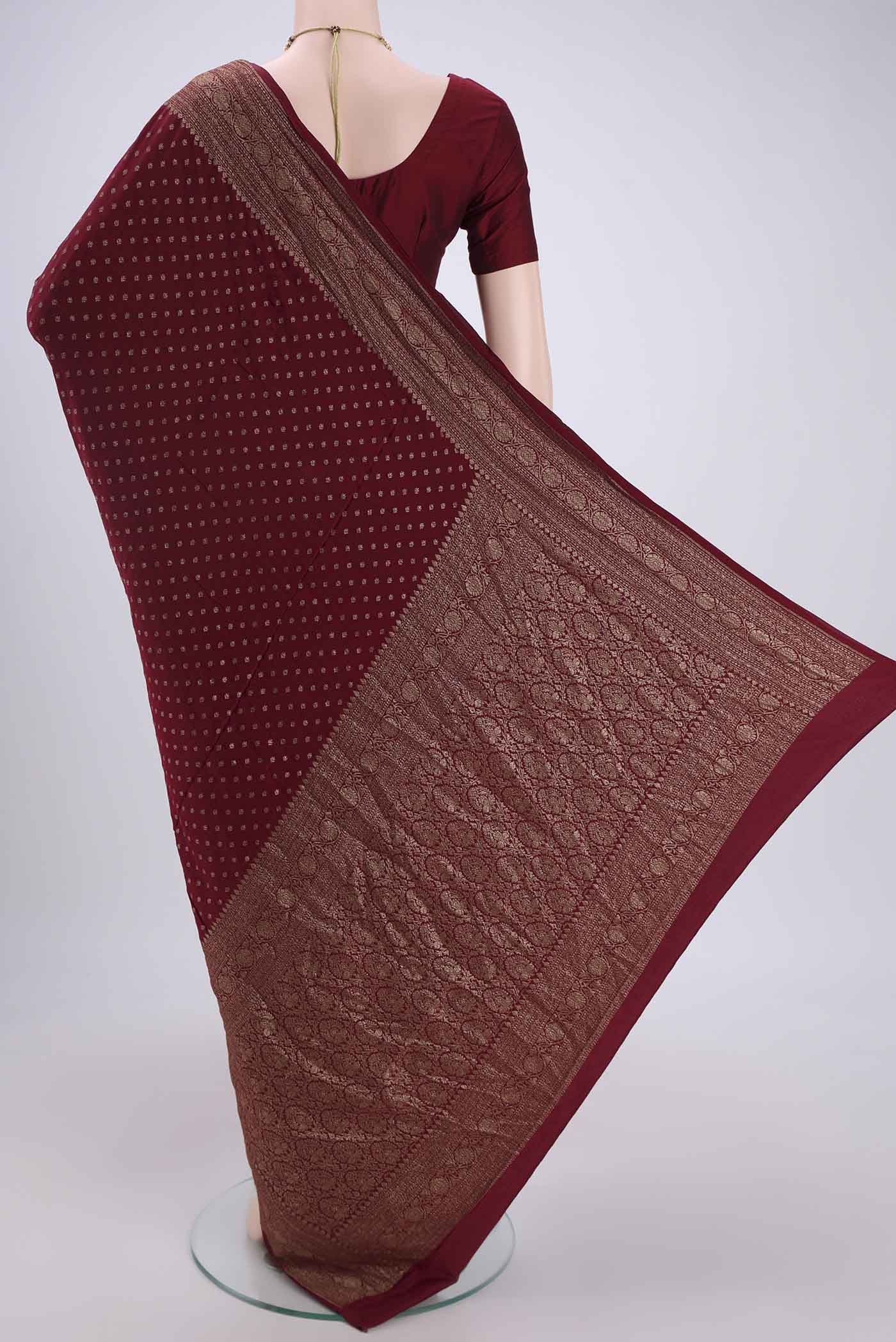 Flat view of Maroon Banarasi Georgette Saree with Zari Butta on the body and Zari Border. 