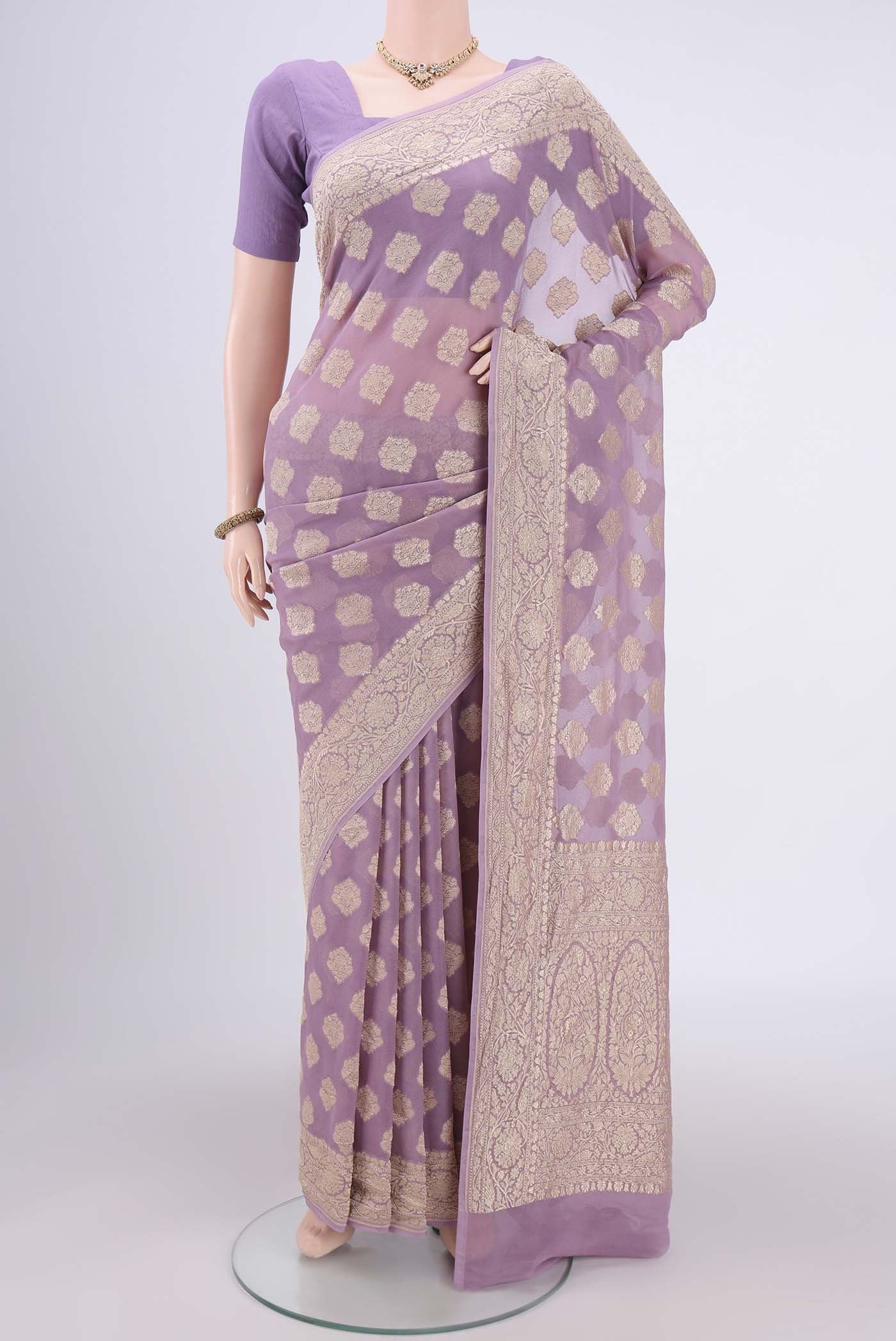 Mauve Banarasi Georgette Saree with Zari Butta on the body and Zari Border.  displayed on a mannequin