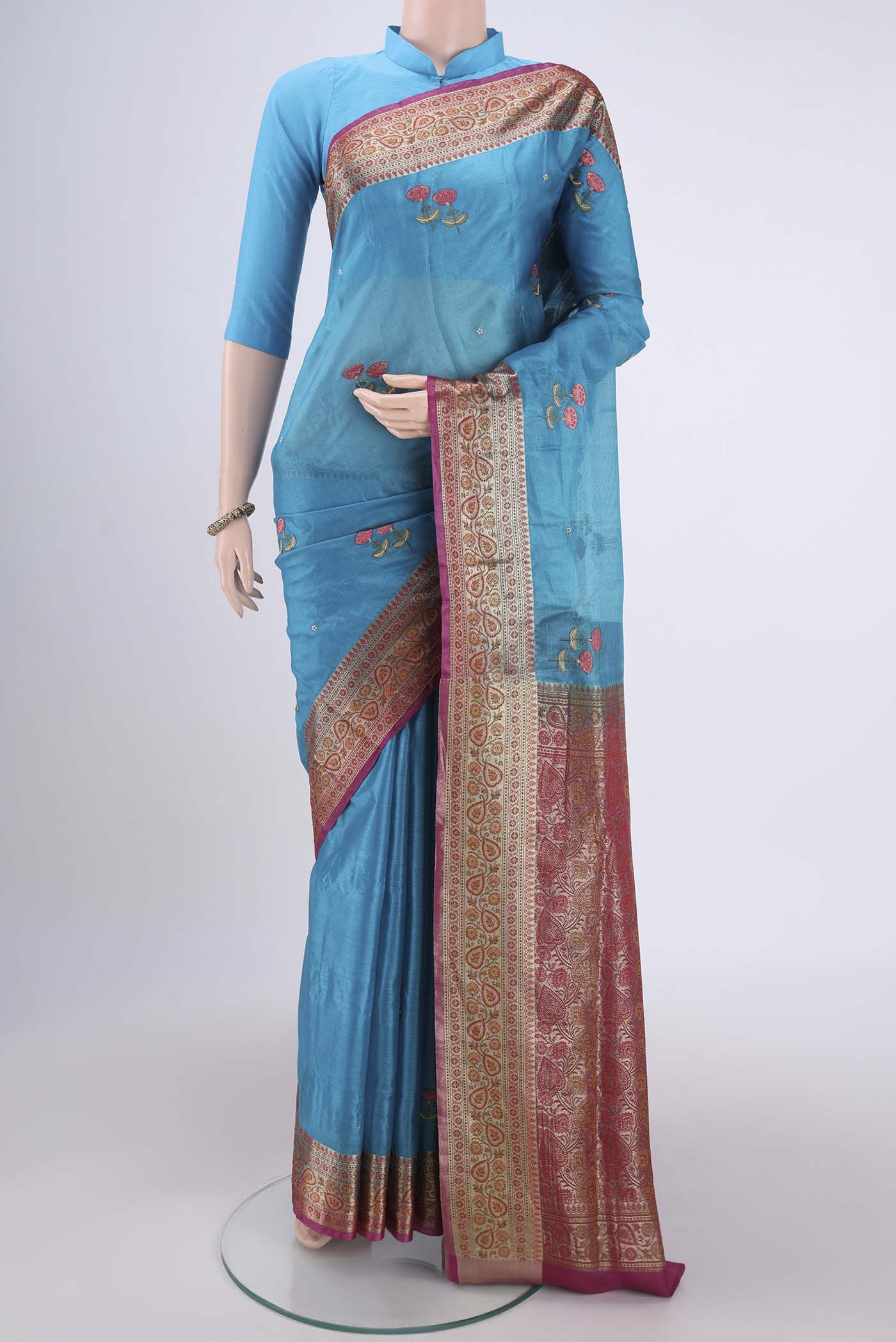 Blue Banarasi Tussar Silk Saree with Embroidery on the body and Zari And Thread Border.  displayed on a mannequin