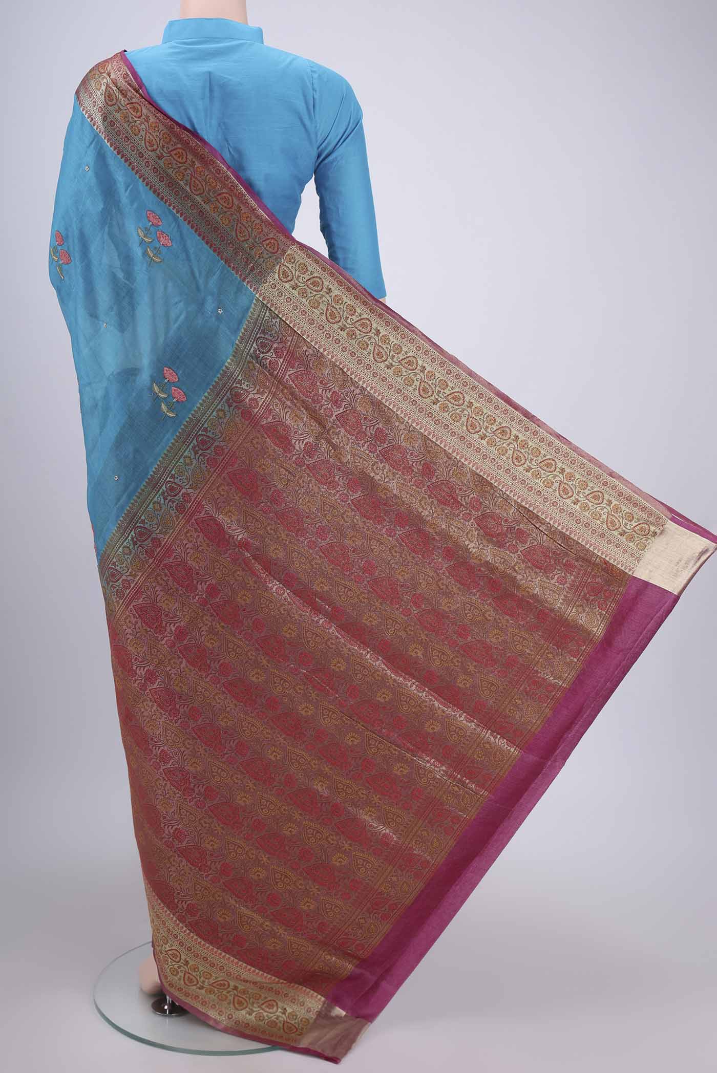 Flat view of Blue Banarasi Tussar Silk Saree with Embroidery on the body and Zari And Thread Border. 