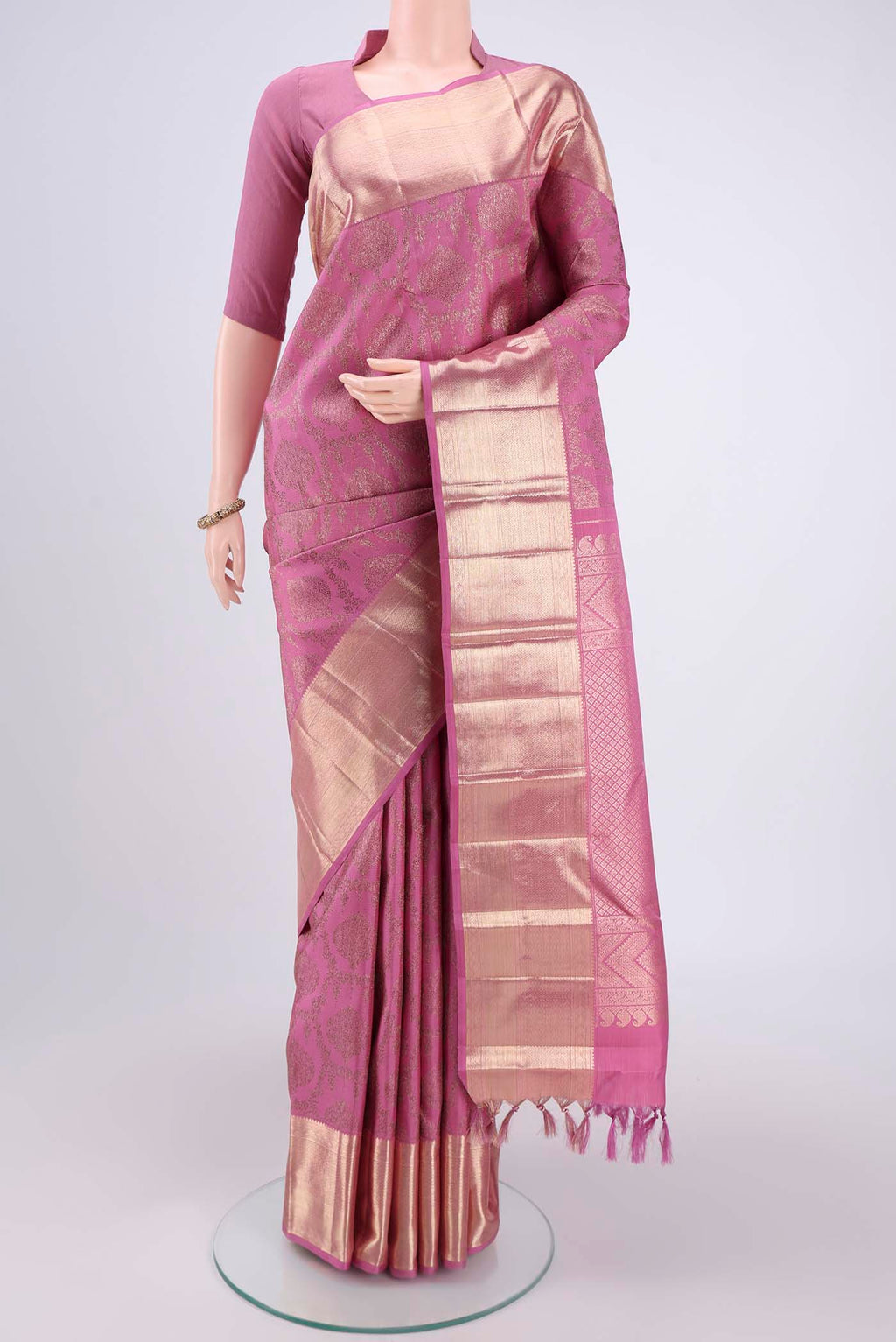 Rose pink Kanchipuram Silk Saree with Zari Butta on the body and Zari Border.  displayed on a mannequin