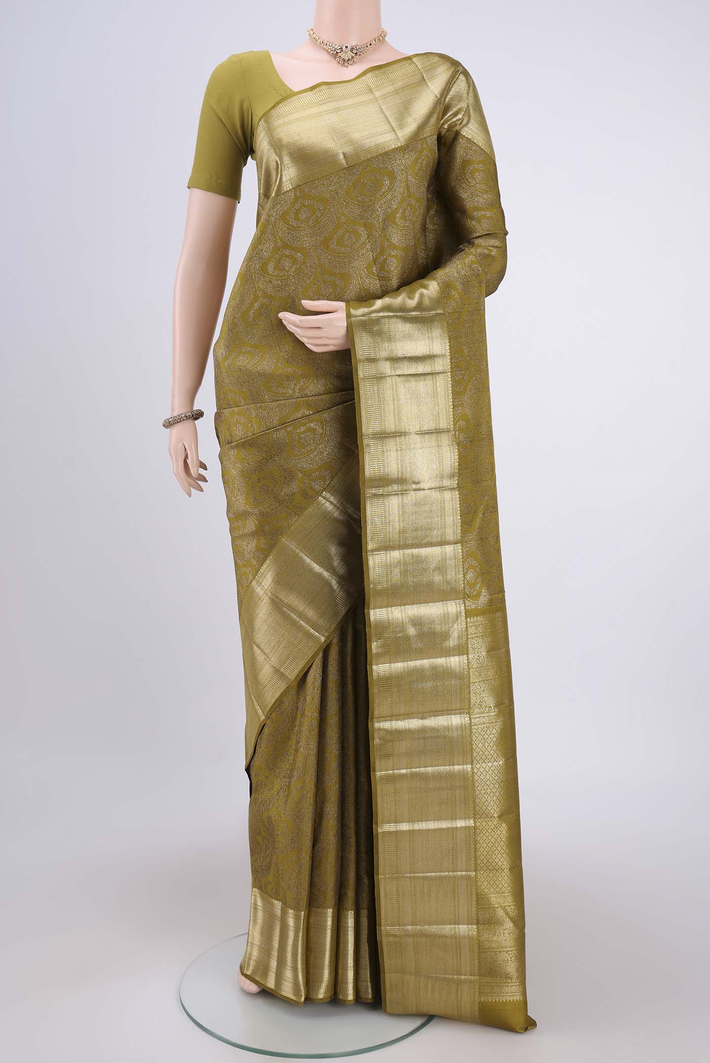 Mehandi Green Kanchipuram Silk Saree with Zari Brocade on the body and Zari Border.  displayed on a mannequin