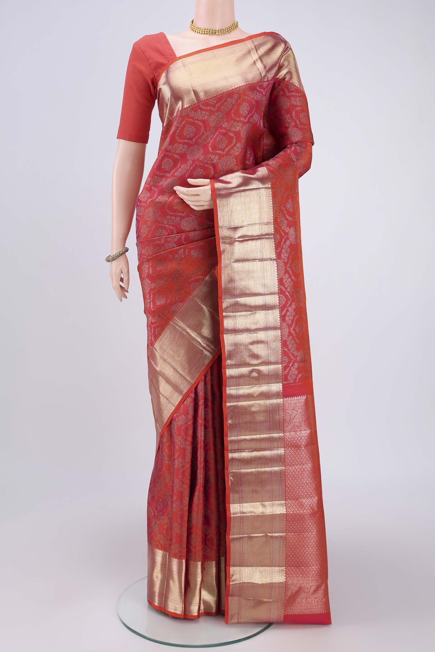 Orange Kanchipuram Silk Saree with Zari Butta on the body and Zari Border.  displayed on a mannequin