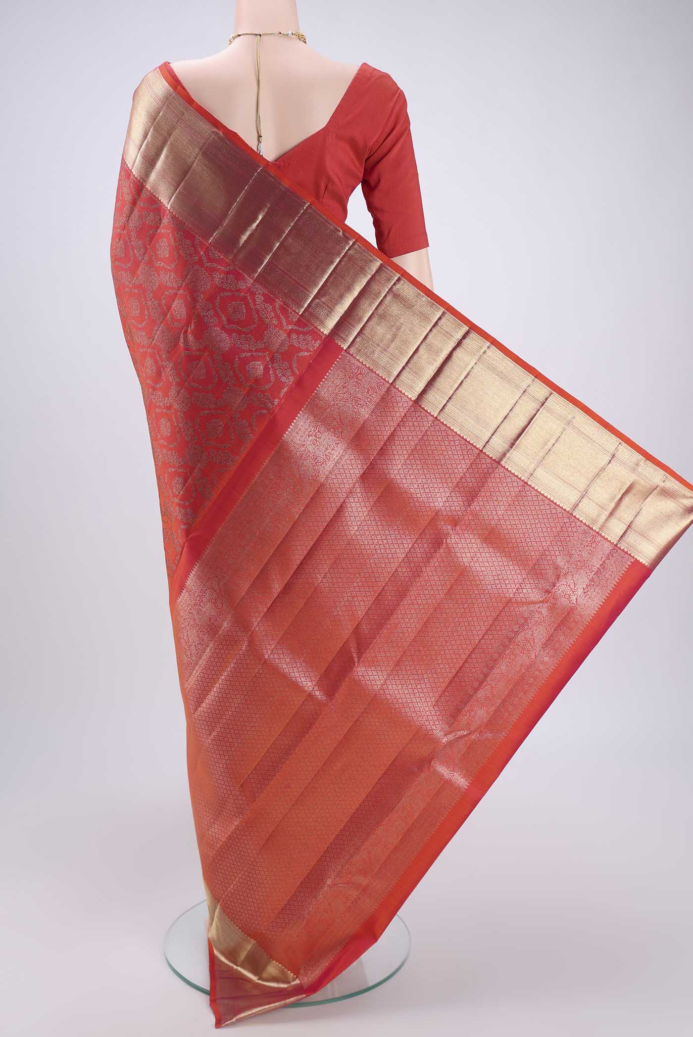 Flat view of Orange Kanchipuram Silk Saree with Zari Butta on the body and Zari Border. 