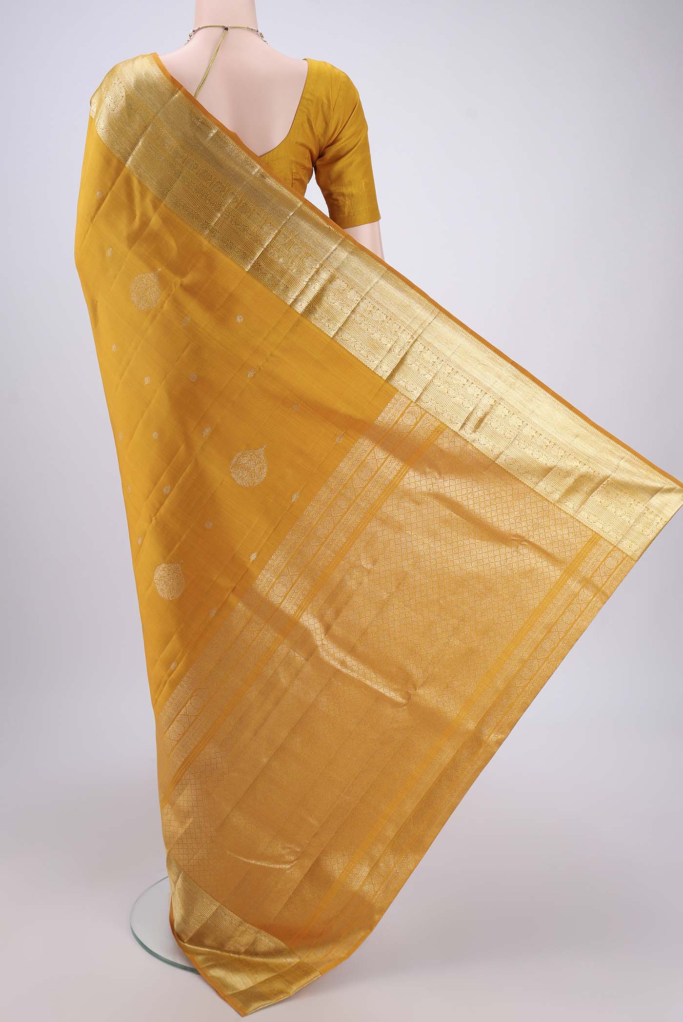 Flat view of Yellow Kanjivaram Silk Saree with Zari Butta on the body and Zari Border. 