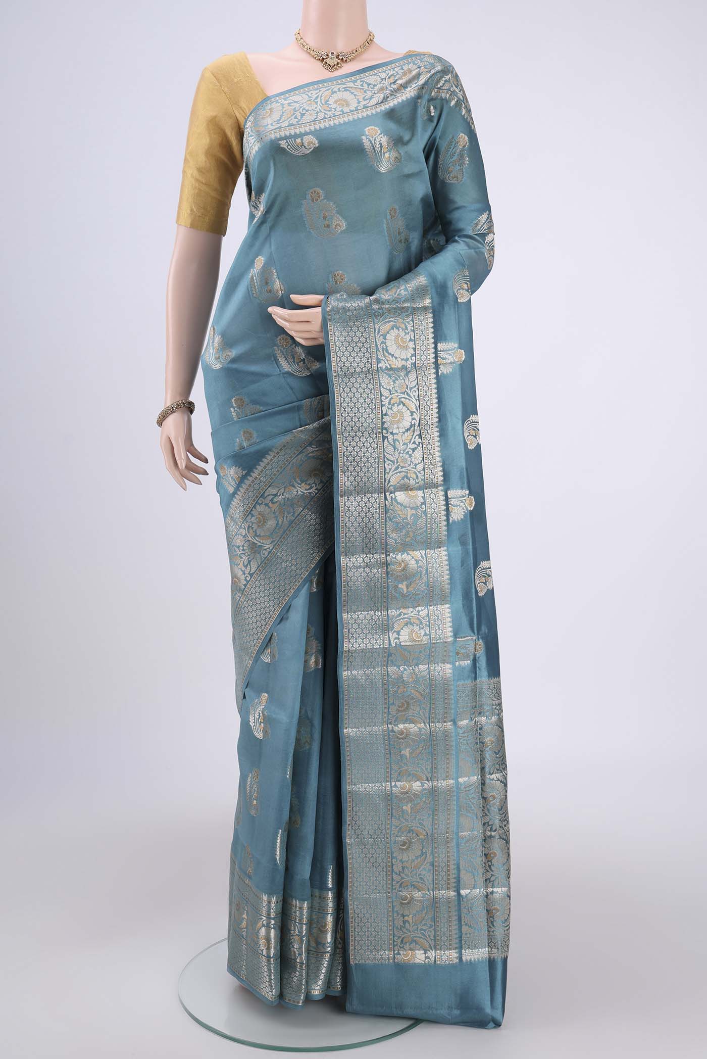 Sky Blue Banarasi Raw Silk Saree with Zari Butta on the body and Zari Border.  displayed on a mannequin