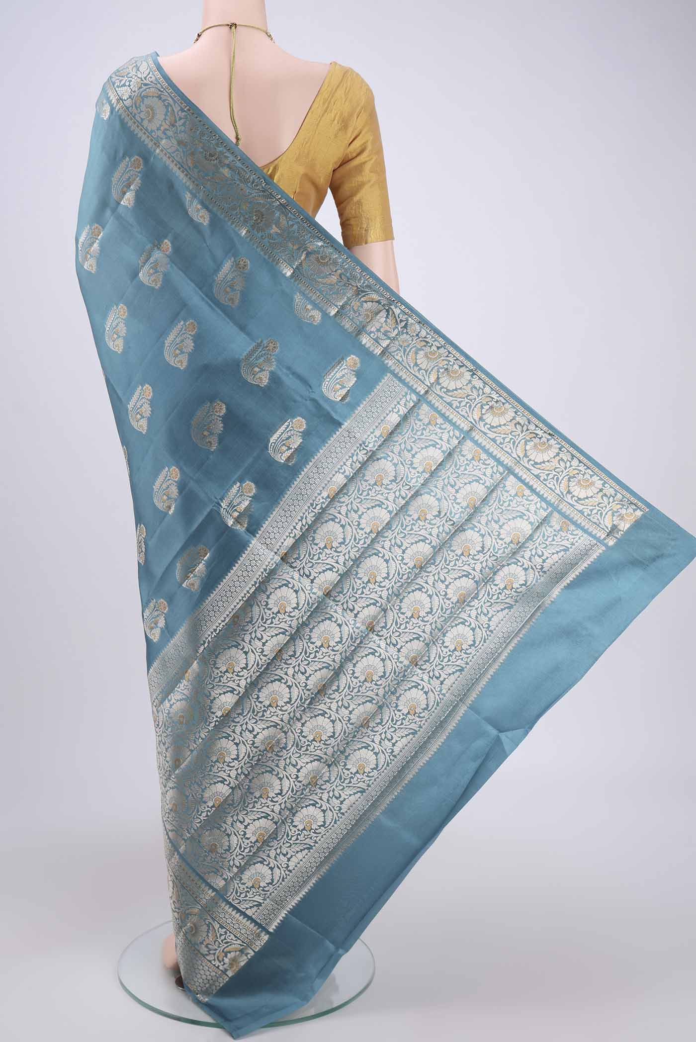 Flat view of Sky Blue Banarasi Raw Silk Saree with Zari Butta on the body and Zari Border. 