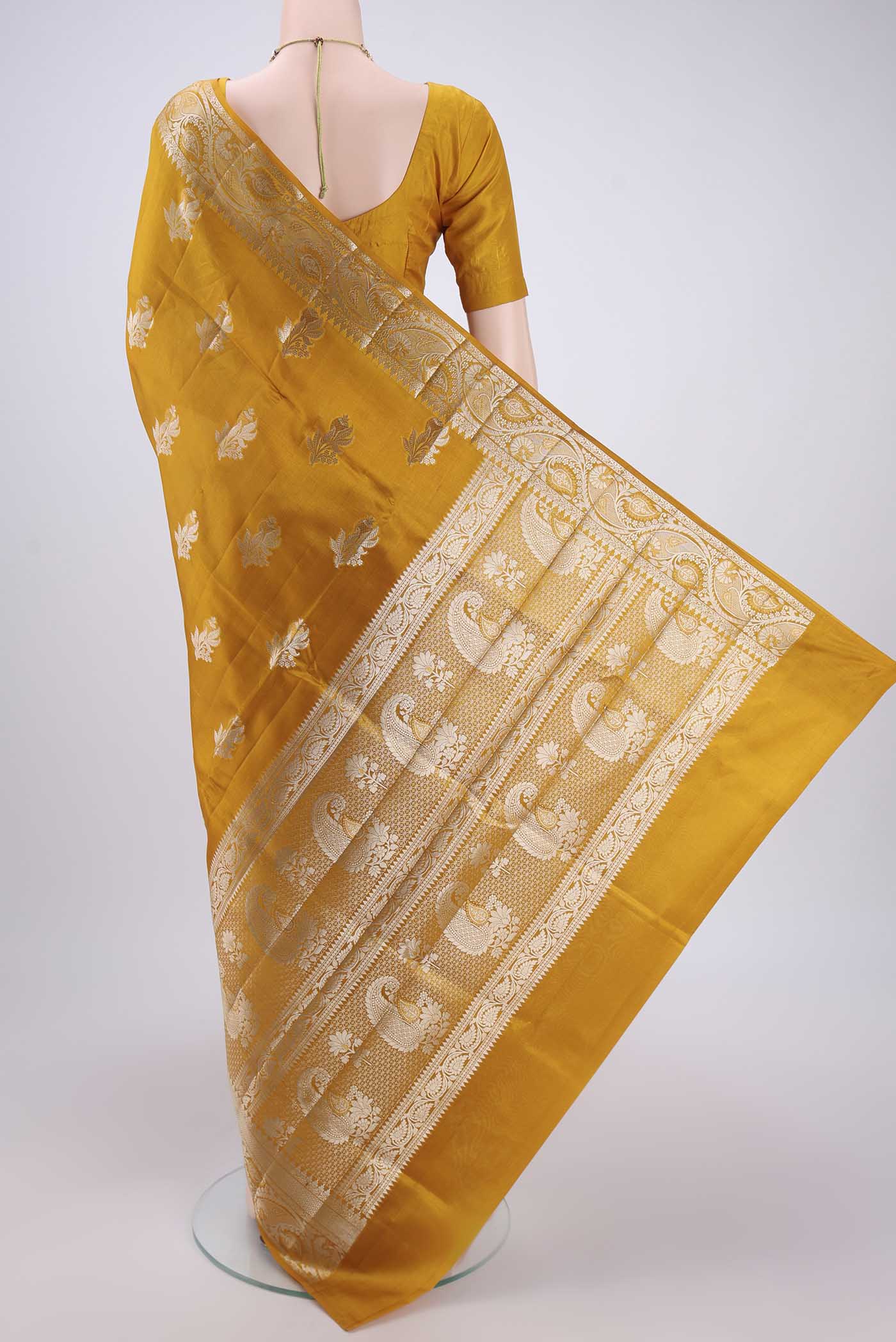 Flat view of Mustard Banarasi Raw Silk Saree with Zari Butta on the body and Zari Border. 