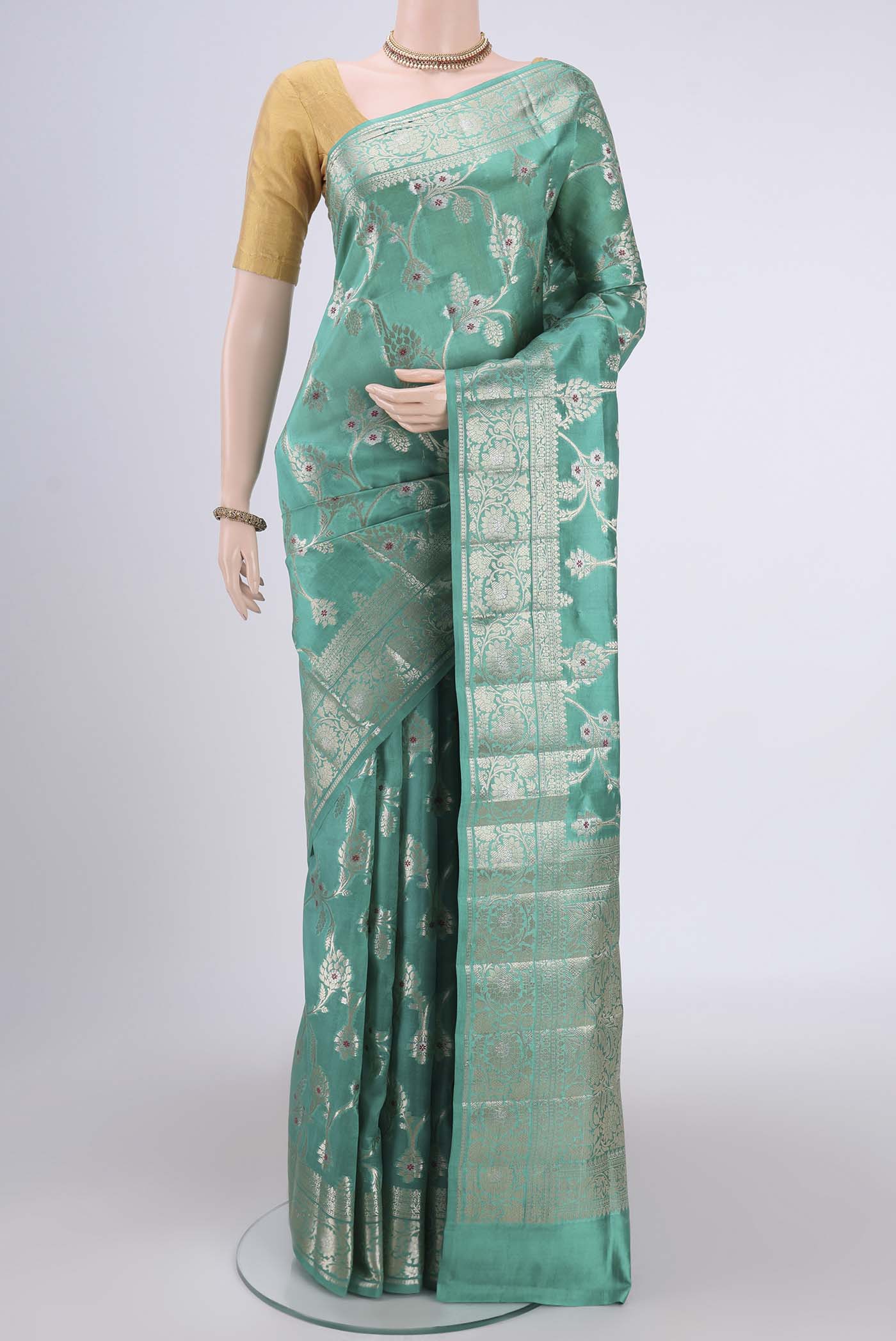Sea Green Banarasi Raw Silk Saree with Zari Butta on the body and Zari Border.  displayed on a mannequin